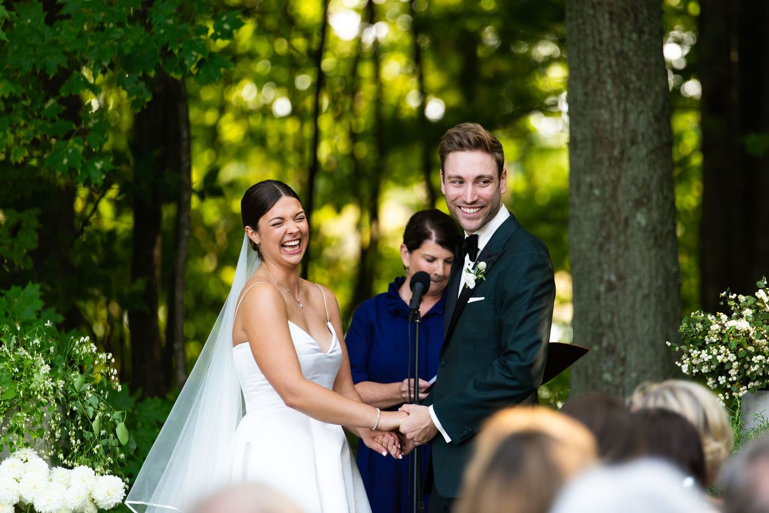 A group of people enjoying a joyous celebration in a lush outdoor garden setting with wine glasses.