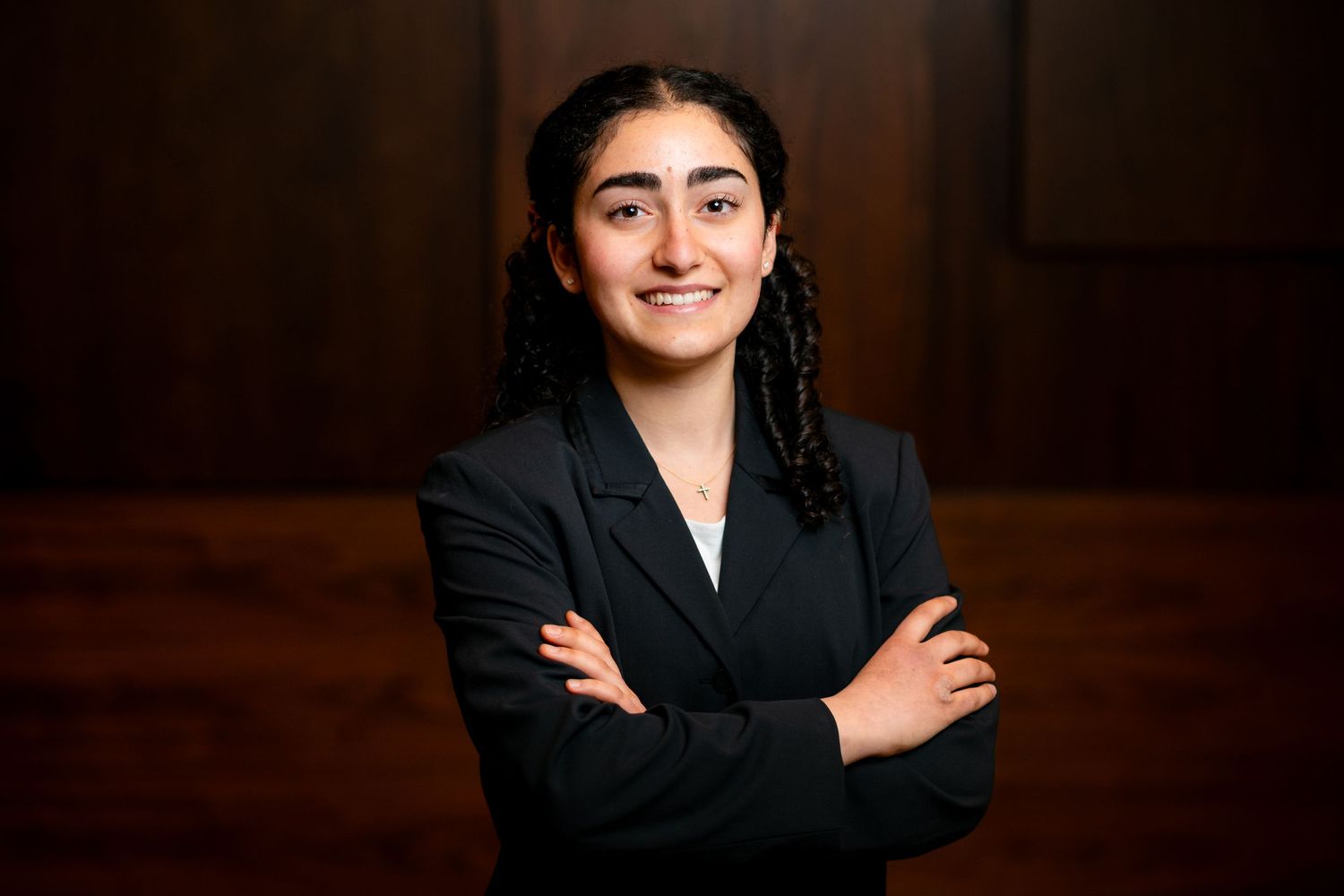 Professional headshot series showing the same person in black blazer against dark background with warm lighting.