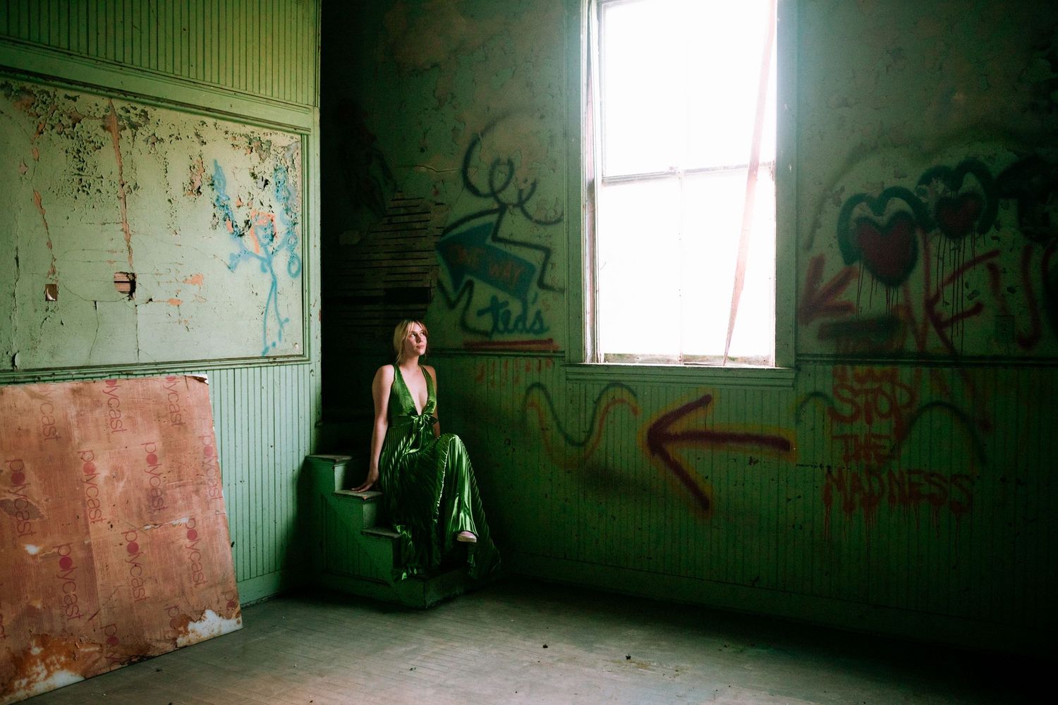 A dark, abandoned room with peeling green walls and graffiti visible in dim lighting through multiple connected images.