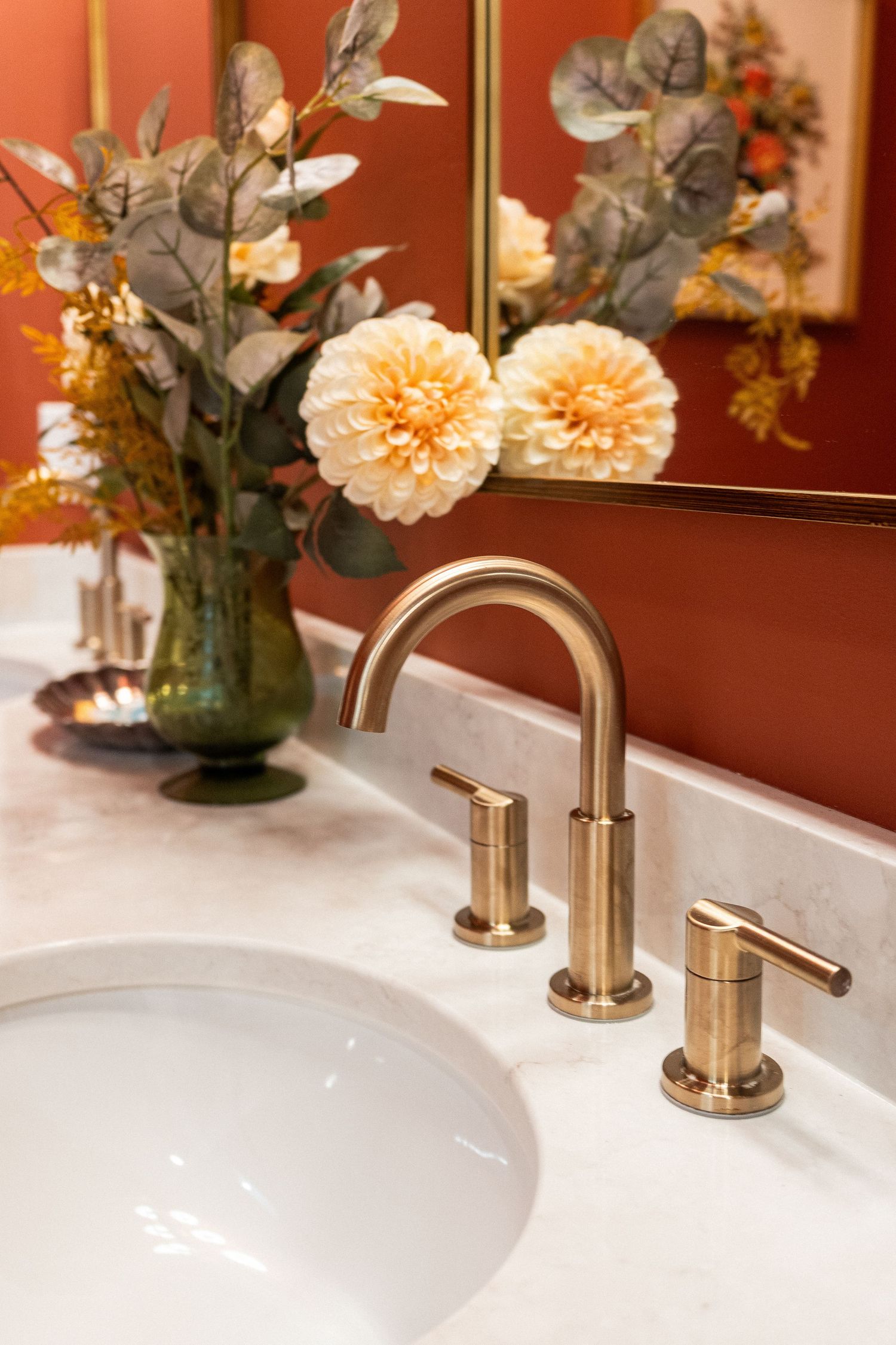 Elegant bathroom counter with peach flowers in vases and brushed nickel faucets for real estate photography in Augusta, GA.