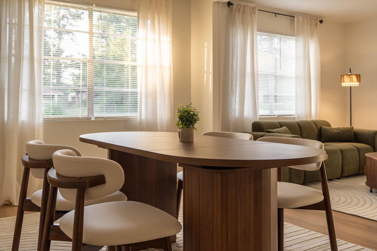 Open dining area with wooden table and chairs near large windows with natural lighting for real estate photography in Augusta, GA.