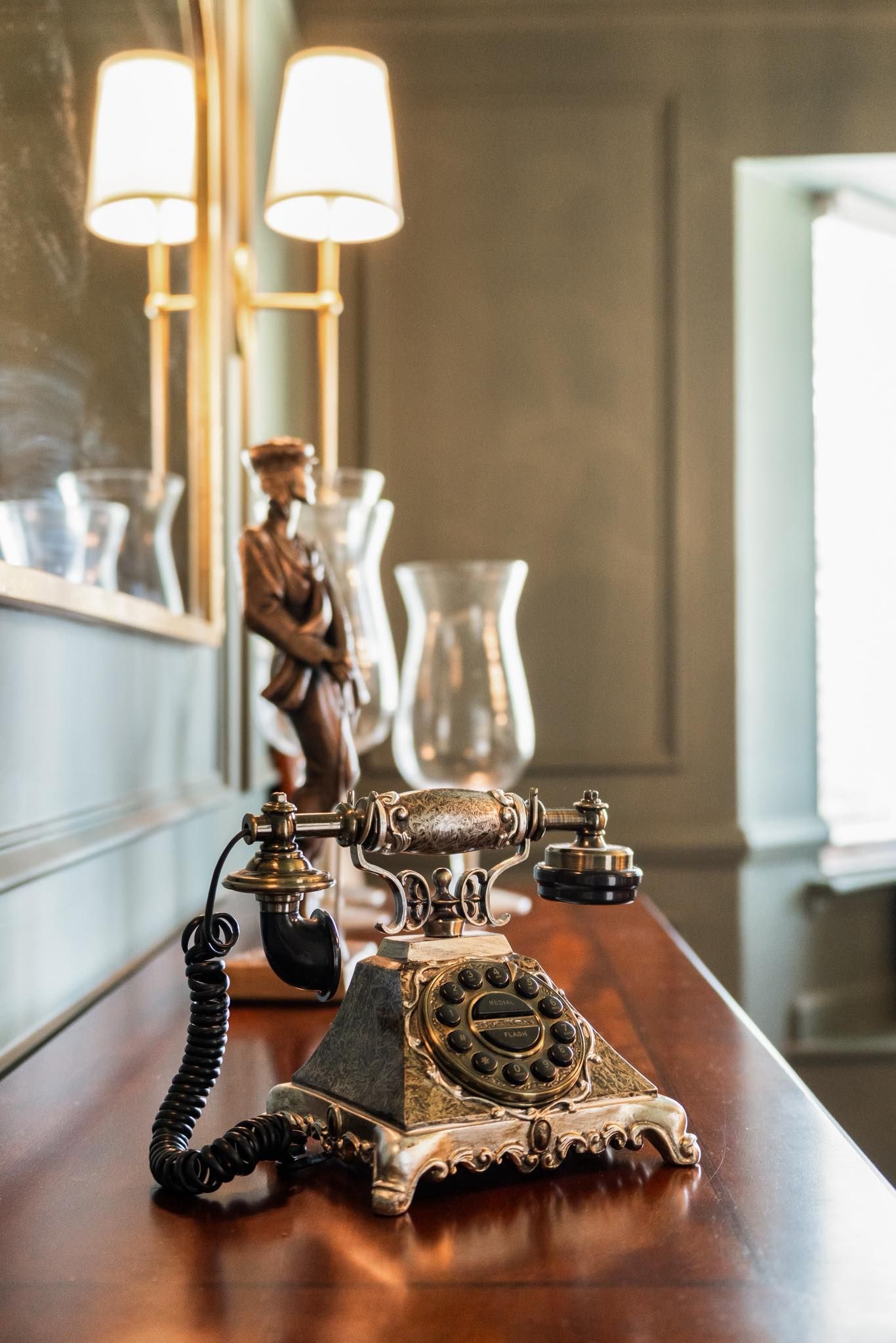 Vintage rotary telephones displayed on wooden table with warm lighting for real estate photography in Augusta, GA.
