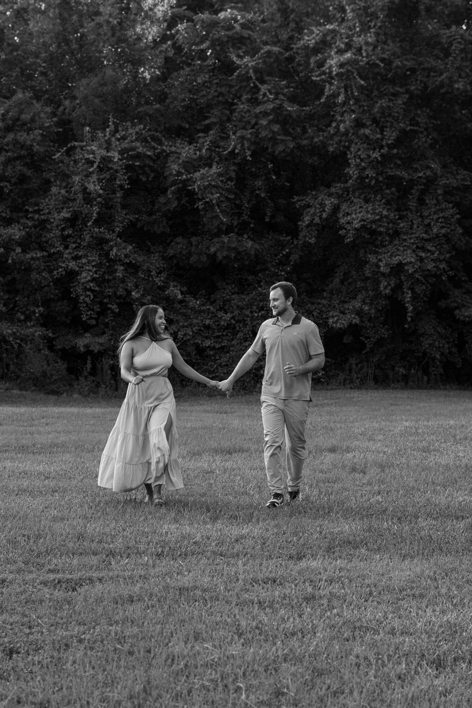 Family enjoying a playful moment together in a field with trees in the background for real estate photography in Augusta, GA.