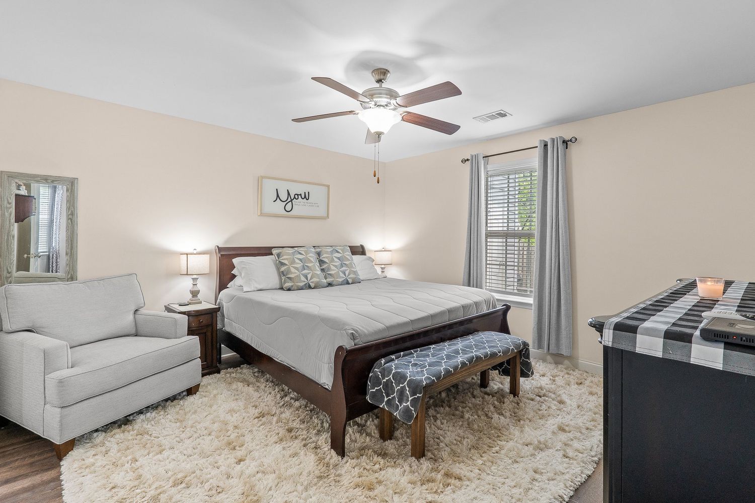 Spacious master bedroom with beige carpet, ceiling fan, and large windows offering natural lighting for real estate photography in Augusta.