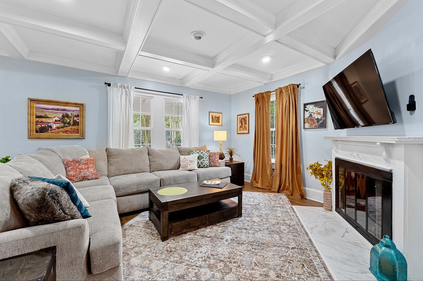 Spacious living room with coffered ceiling, plush sectional sofa, and coastal-inspired decor for real estate photography in Augusta, GA.