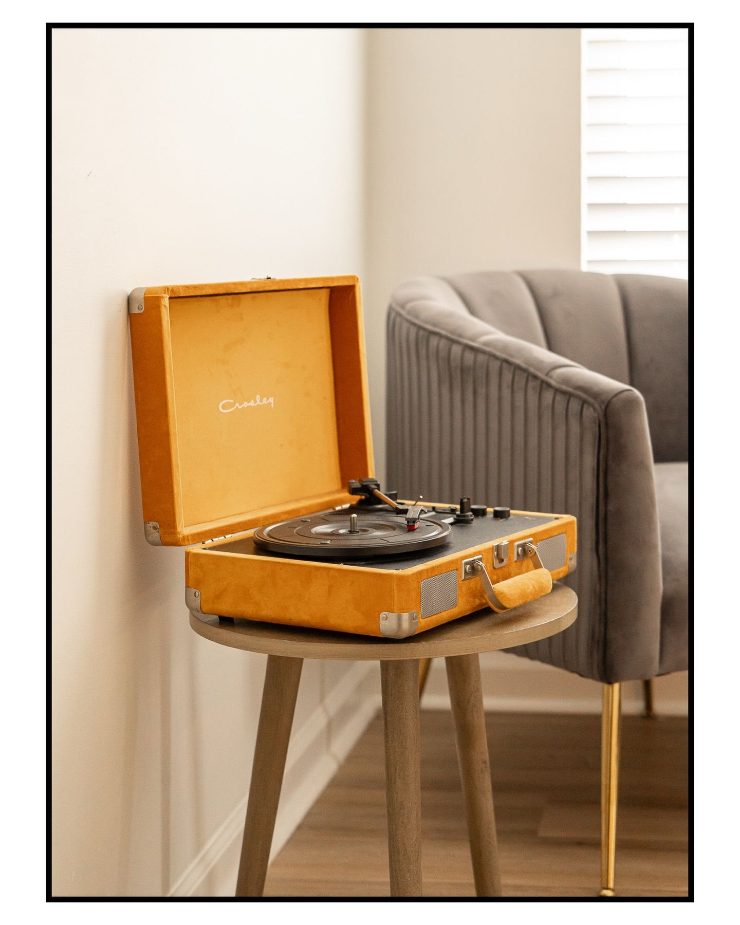 Vintage orange record player displayed on modern gray side table for real estate photography in Augusta, GA.