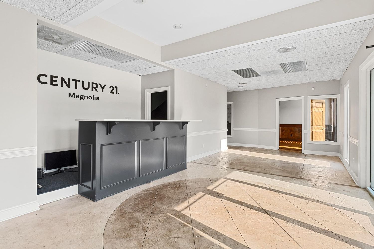 Modern basement recreation room with white walls, recessed lighting, and wall-mounted television for real estate photography in Augusta, GA.