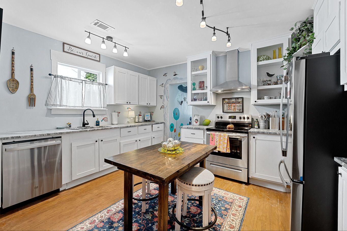 Bright kitchen with white cabinetry, butcher block countertops, and track lighting for real estate photography in Augusta, GA.