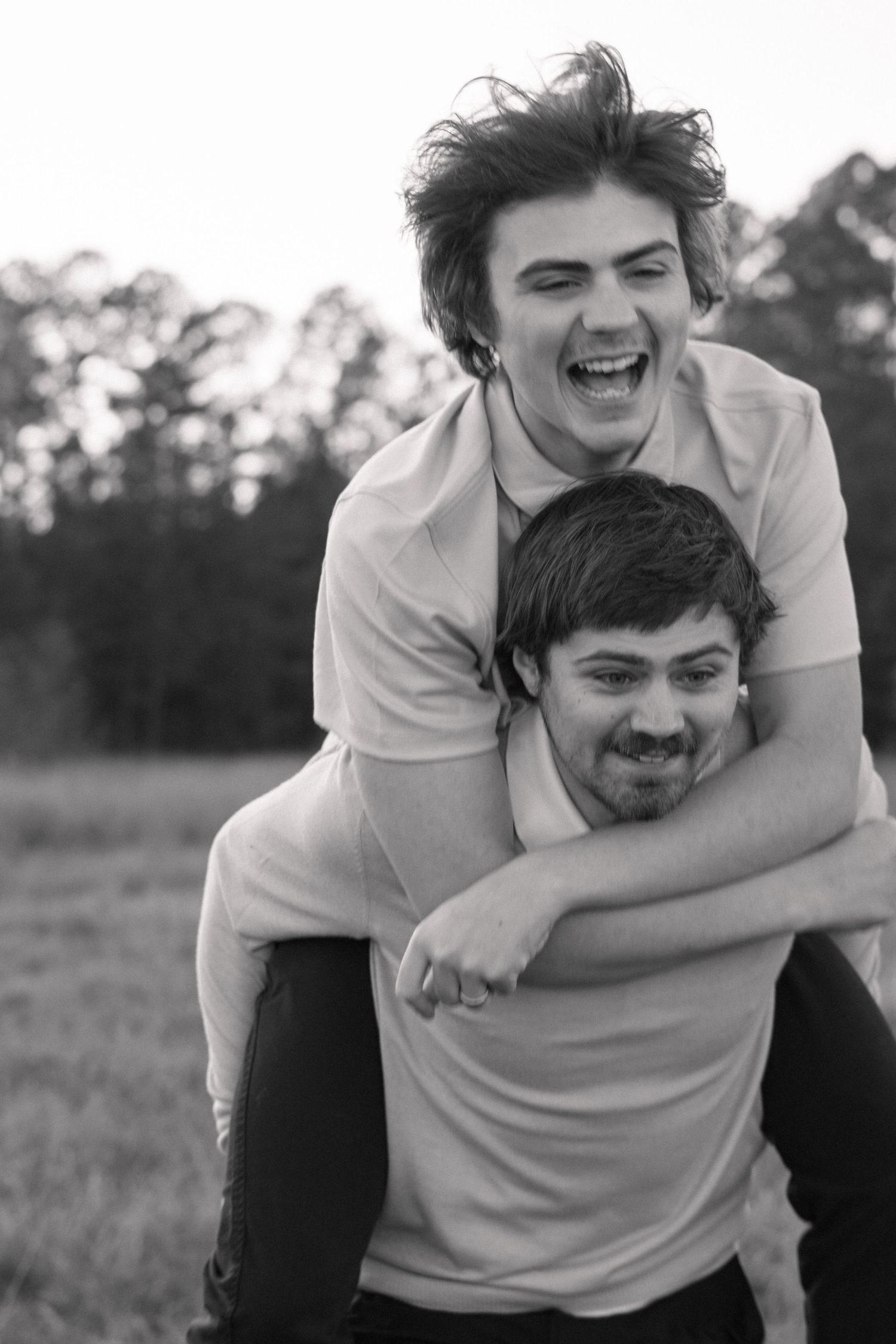 Playful black and white portrait of two people sharing joyful moment outdoors in Augusta GA.