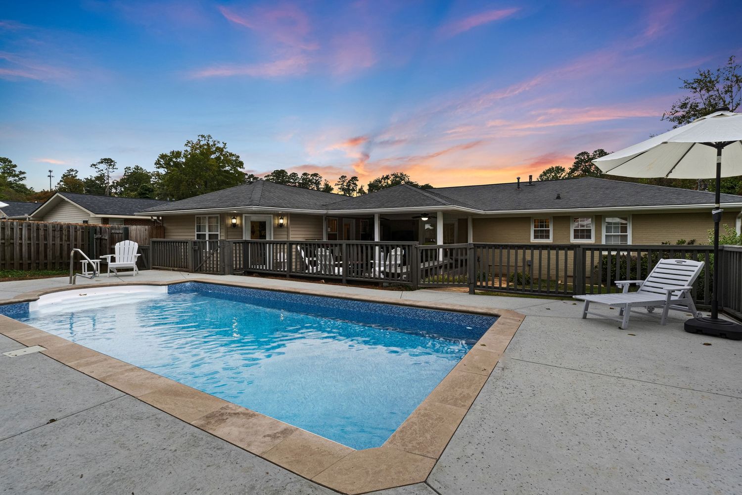 A luxurious swimming pool with crystal clear water reflects the vibrant sunset sky in multiple angles.