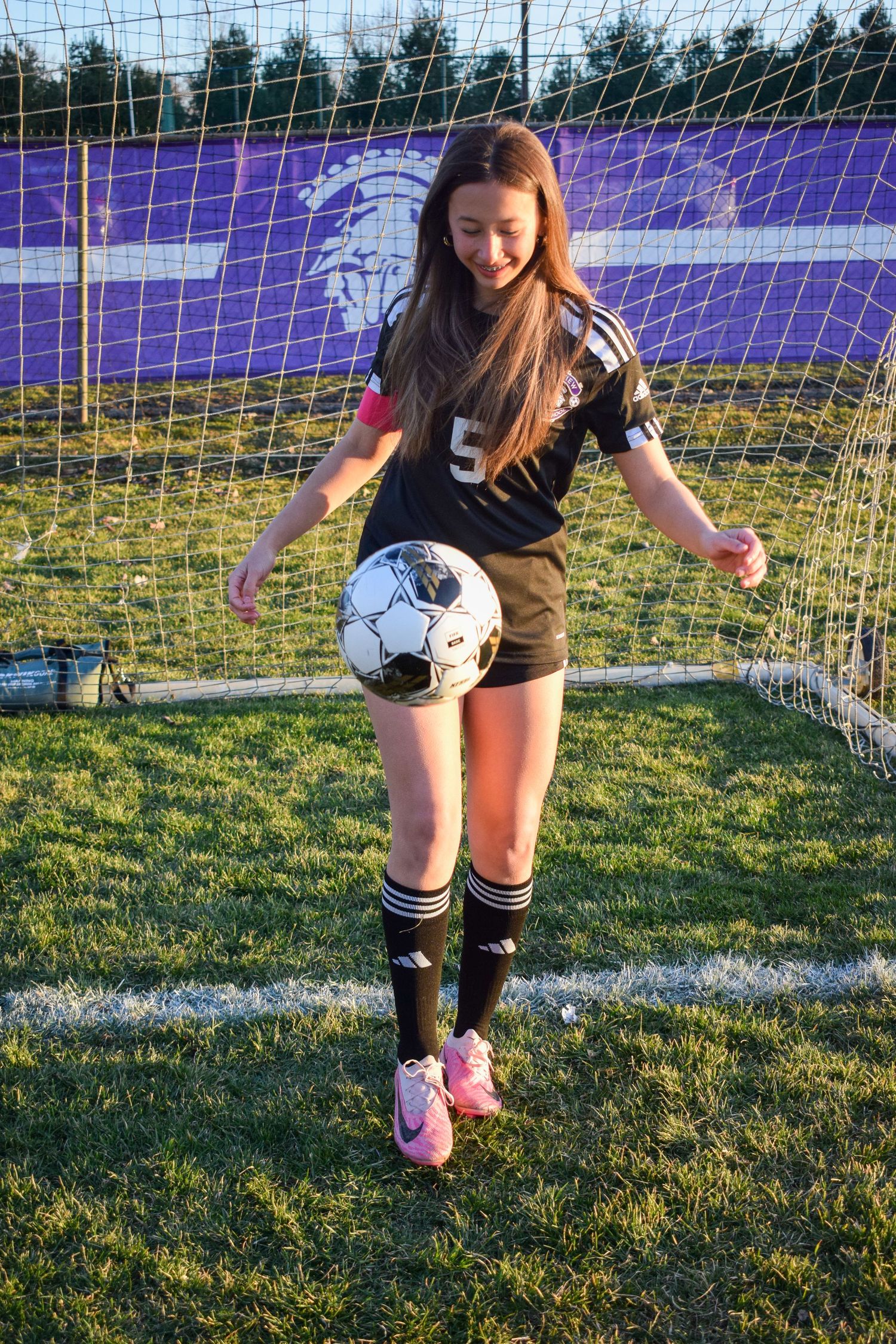 Soccer player demonstrates footwork drills near goal net during practice session.