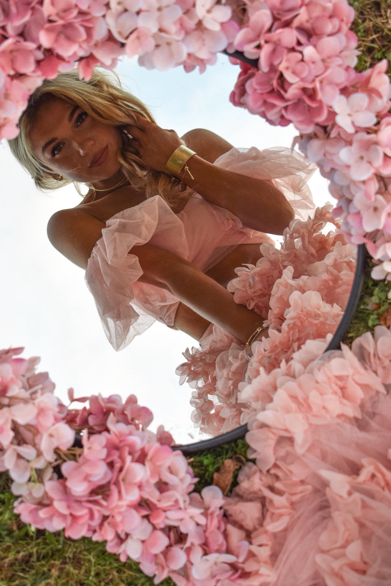 Artistic portrait framed by delicate pink cherry blossoms creating romantic spring atmosphere.