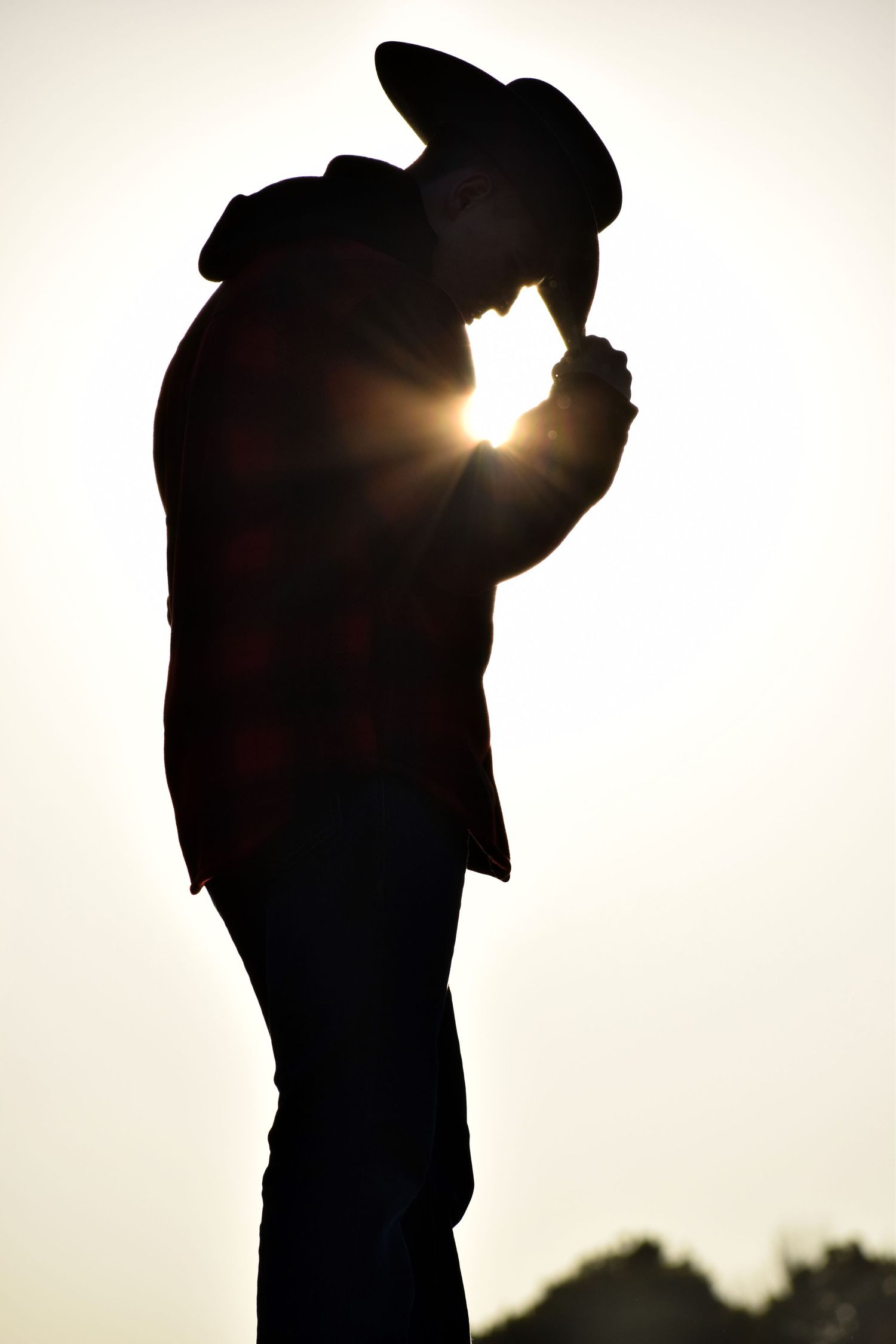 Dramatic silhouette portraits against a bright white sky during golden hour.