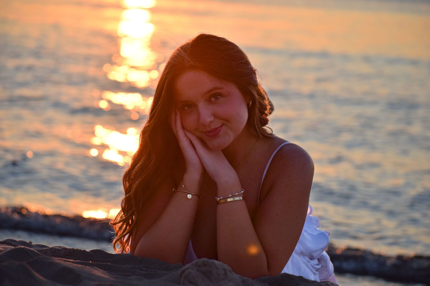 Sunset beach portrait with golden light reflecting on ocean waves.