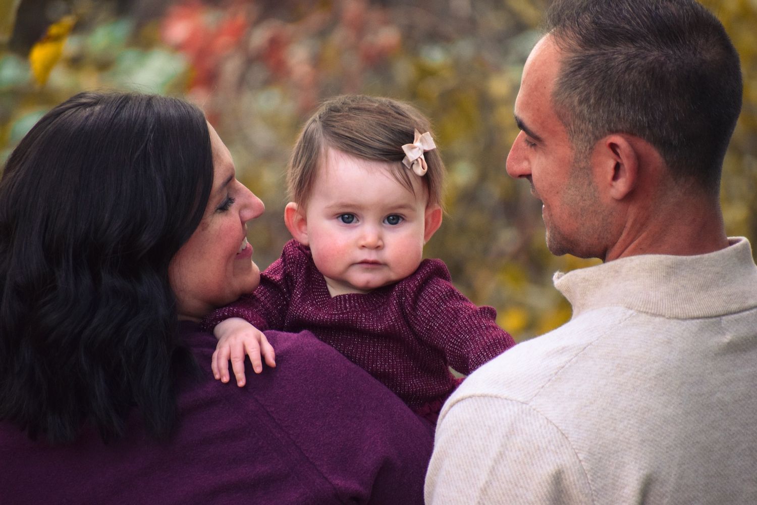 Candid family interaction captured during fall photo session with warm autumn colors.