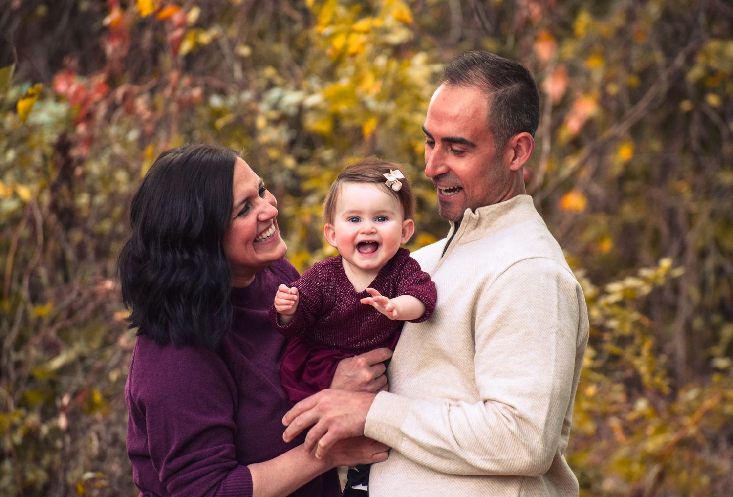 Family enjoying autumn moments together among colorful fall foliage.