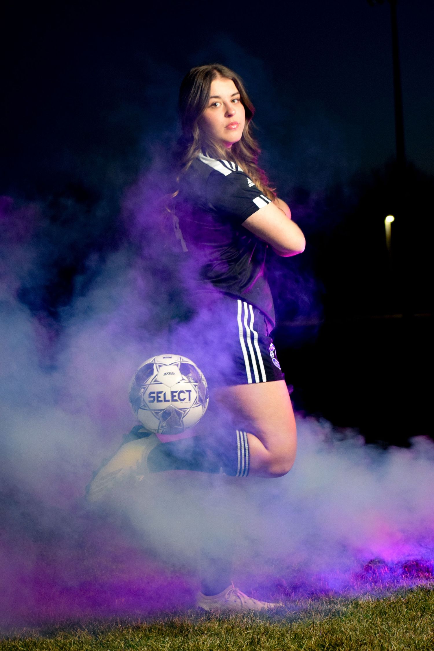 Soccer player with ball creating dynamic poses in purple smoke effects.