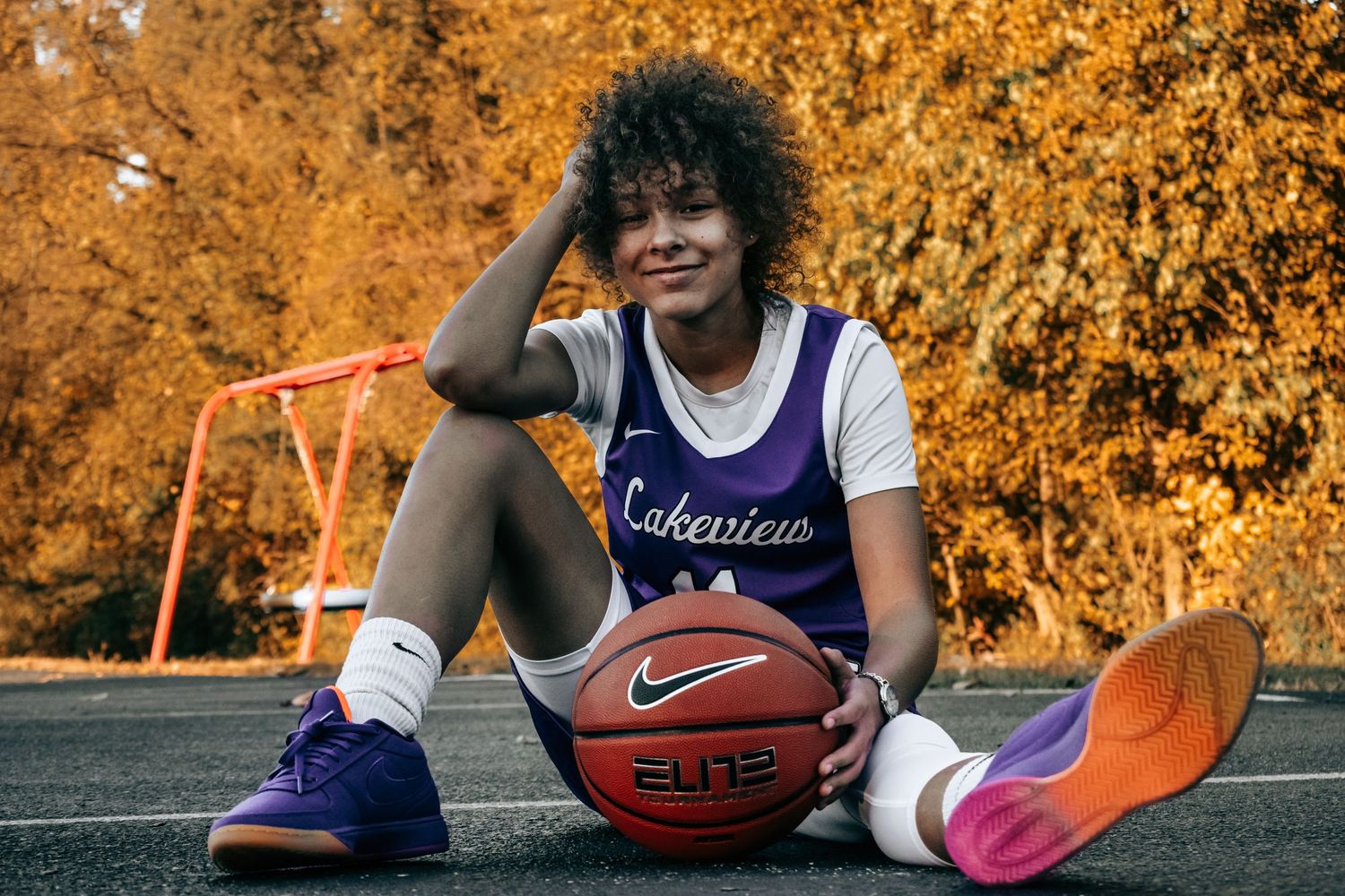 Basketball practice session at sunset with golden autumn foliage in the background.