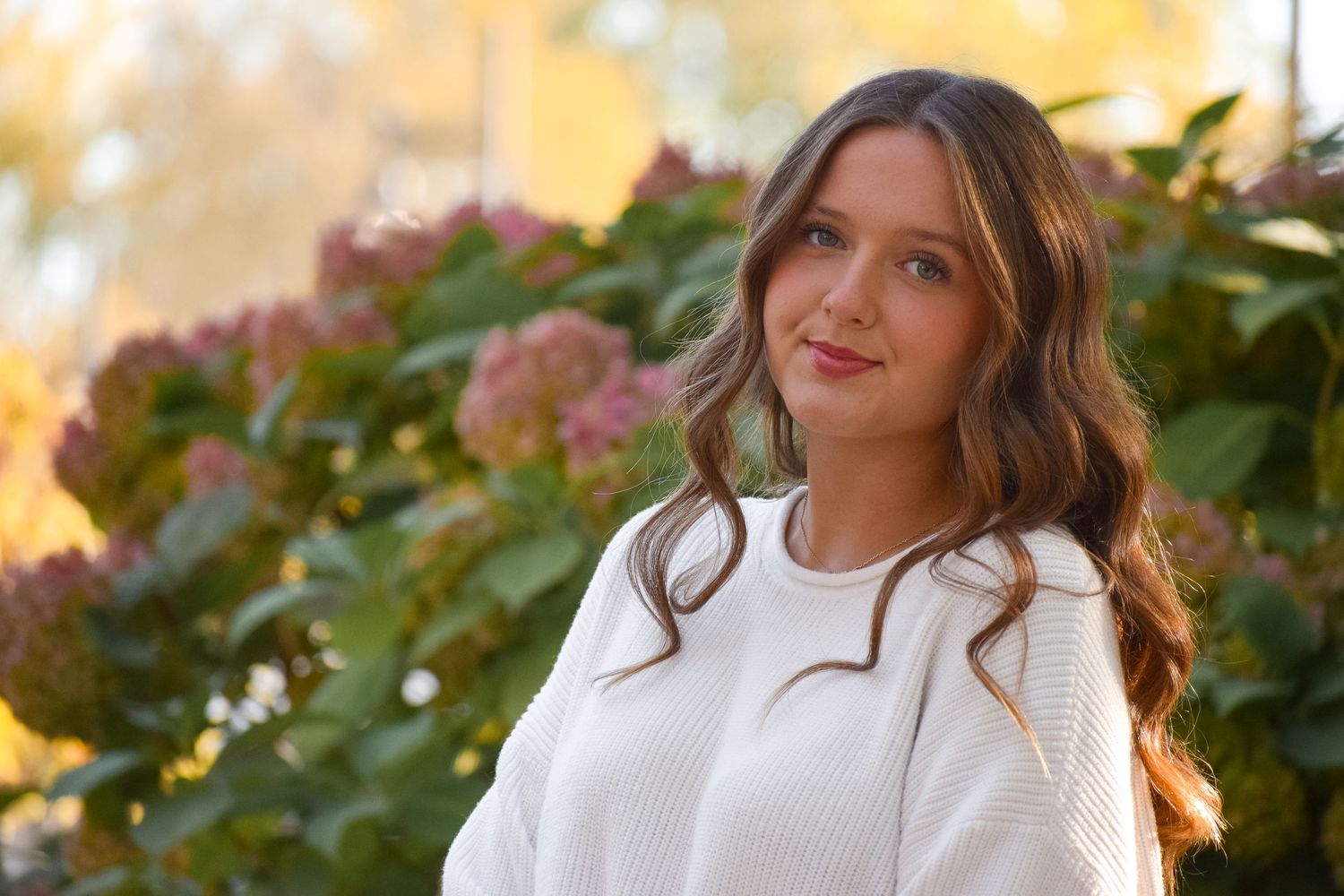 Fashion portrait series with autumn foliage and warm lighting.