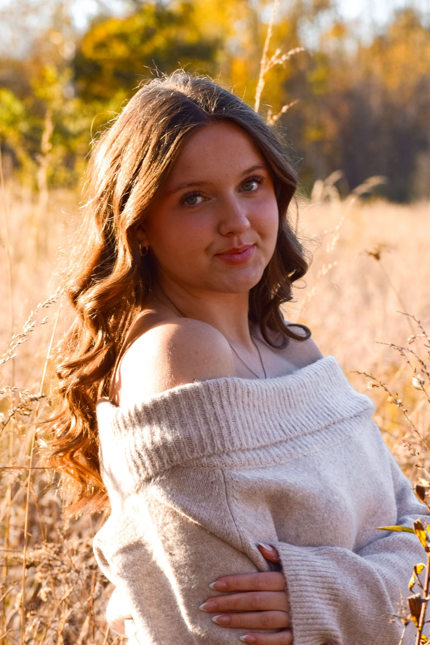 Autumn fashion shoot featuring beige sweater in golden field setting.