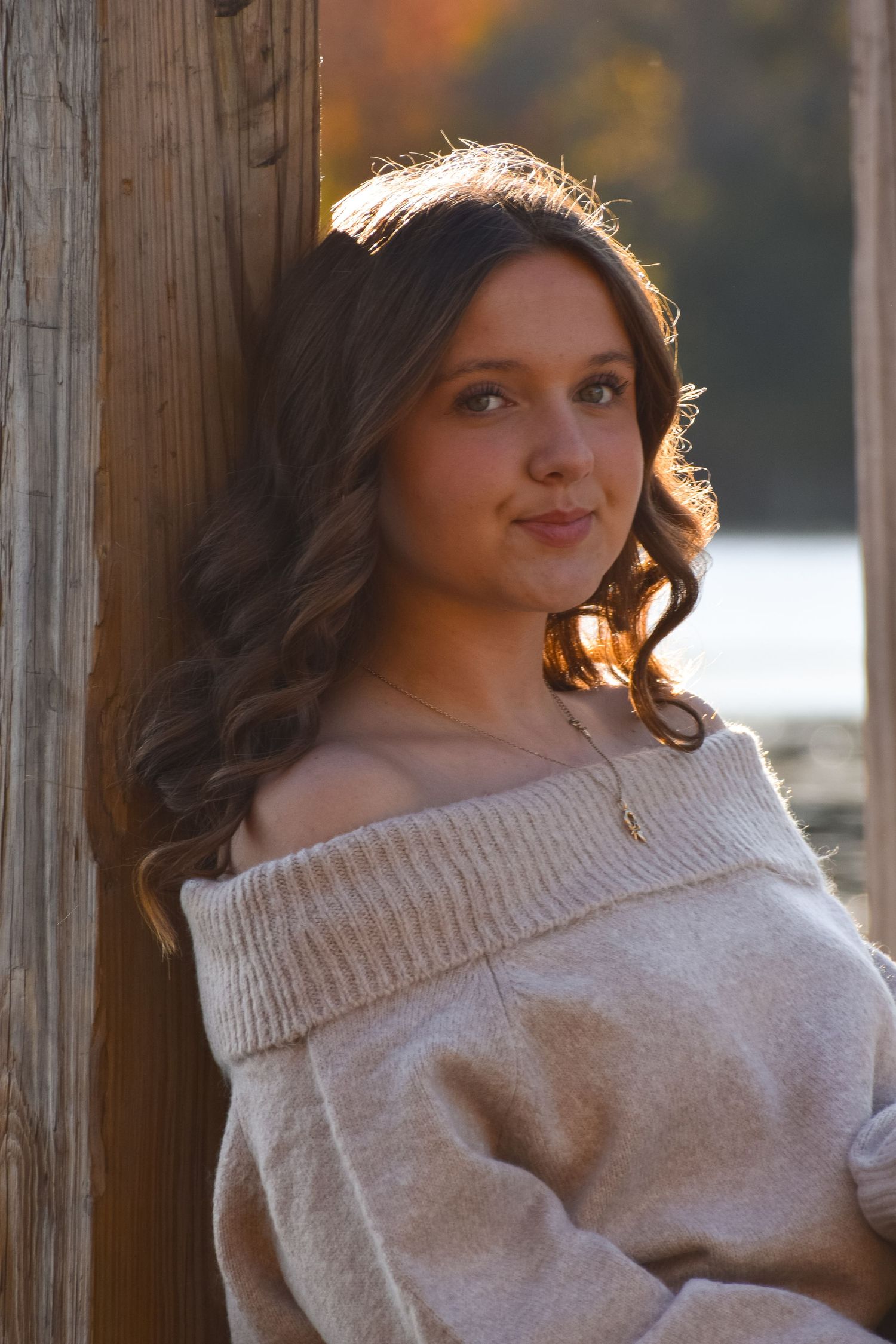Casual off-shoulder beige sweater portraits against rustic wooden backdrop.