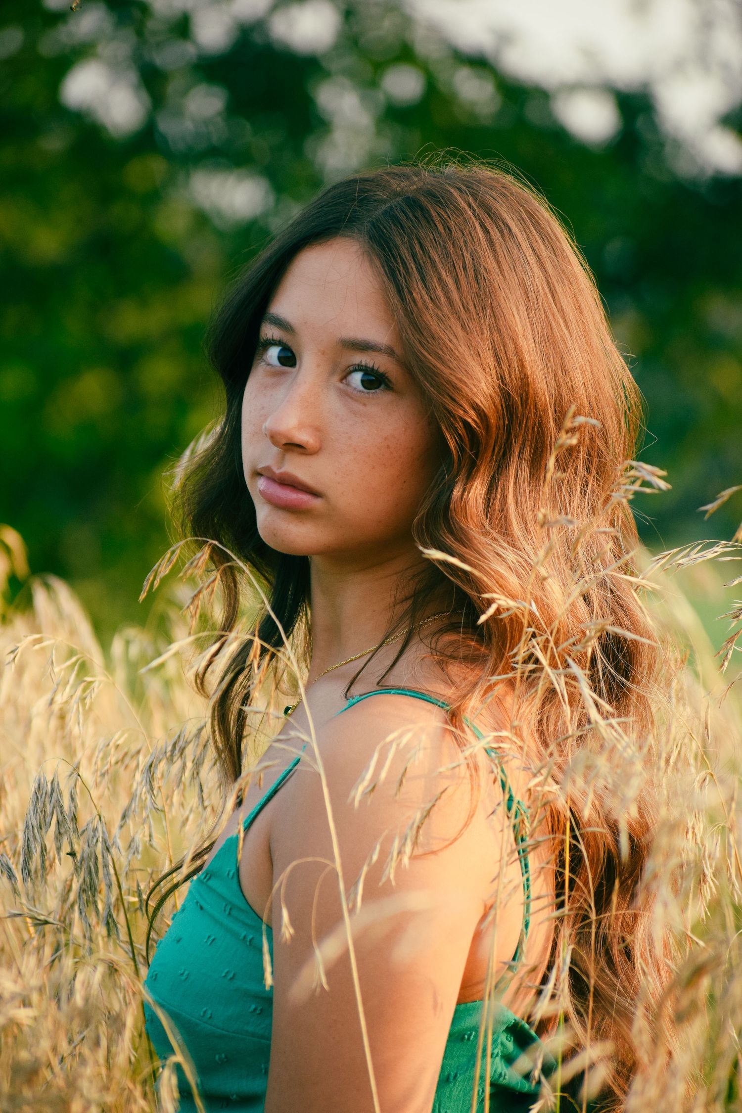 Ethereal portraits in a wheat field with golden sunlight illuminating long hair.