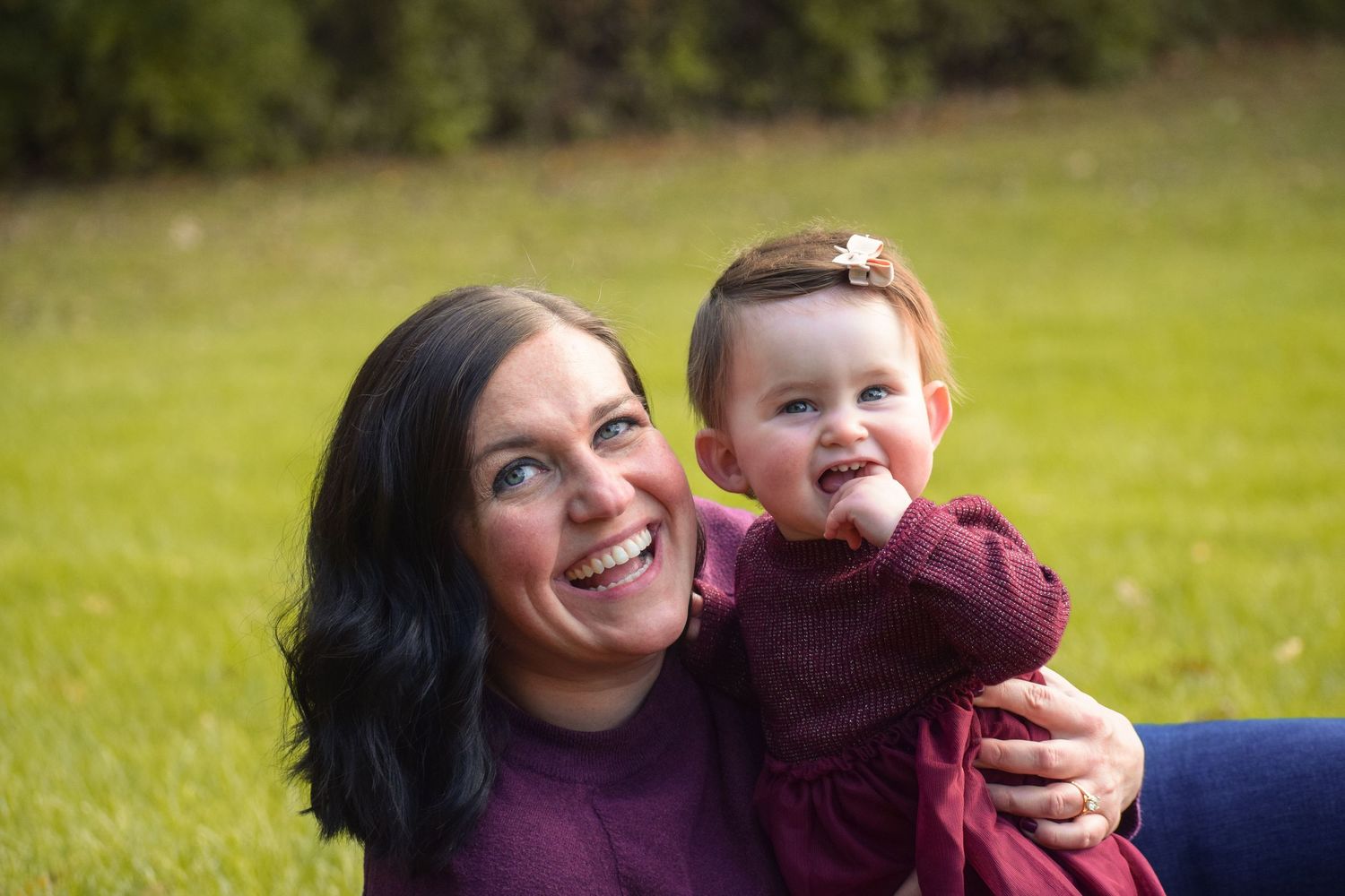 Playful autumn outdoor scene with burgundy and navy clothing against fall foliage.