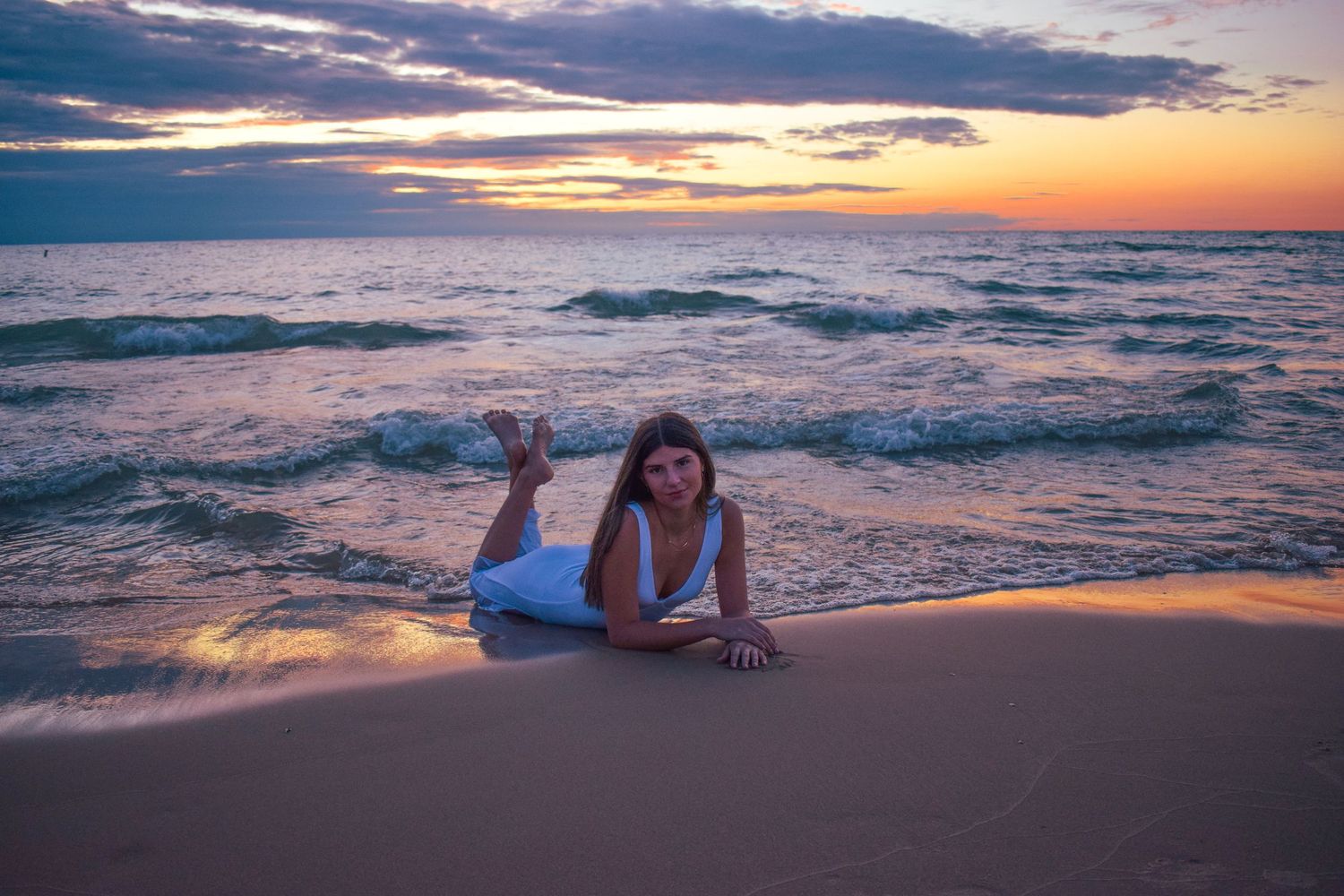 Beautiful sunset beach scene with waves crashing on shore.