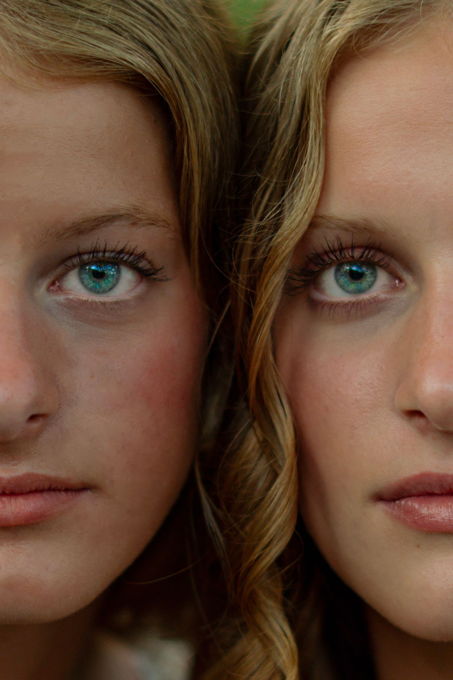 Close-up photo showing striking bright blue eyes and soft brown hair against a neutral background.
