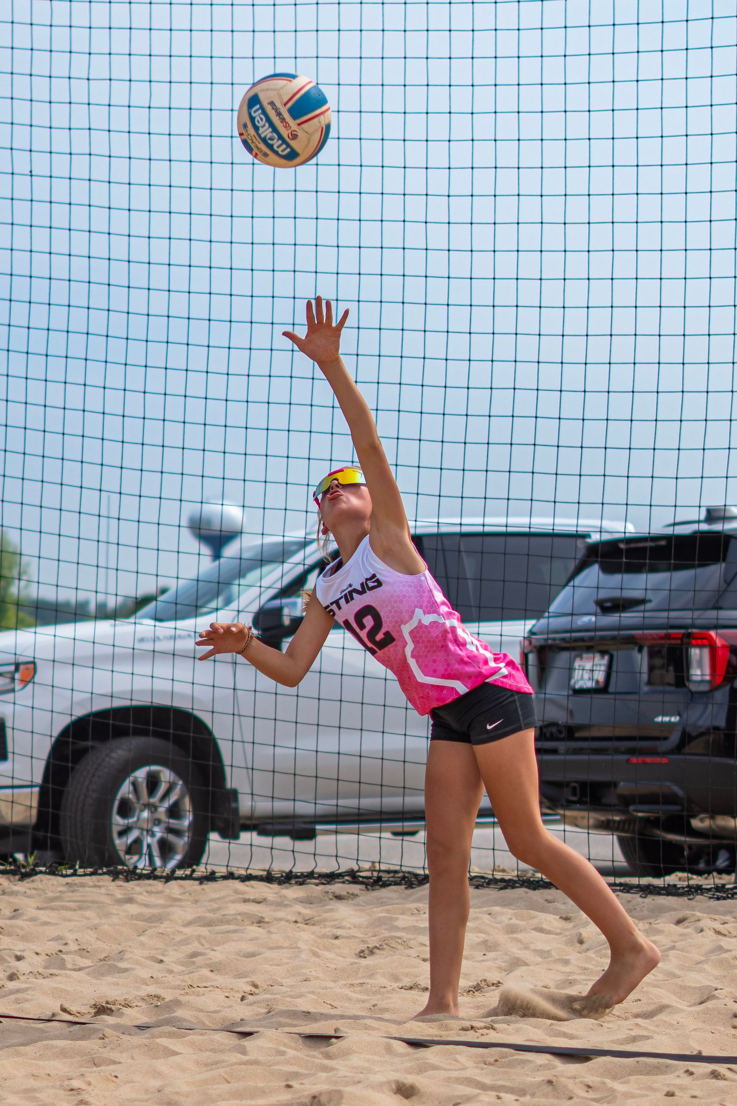 Players execute diving saves to keep the volleyball in play during a beach match.