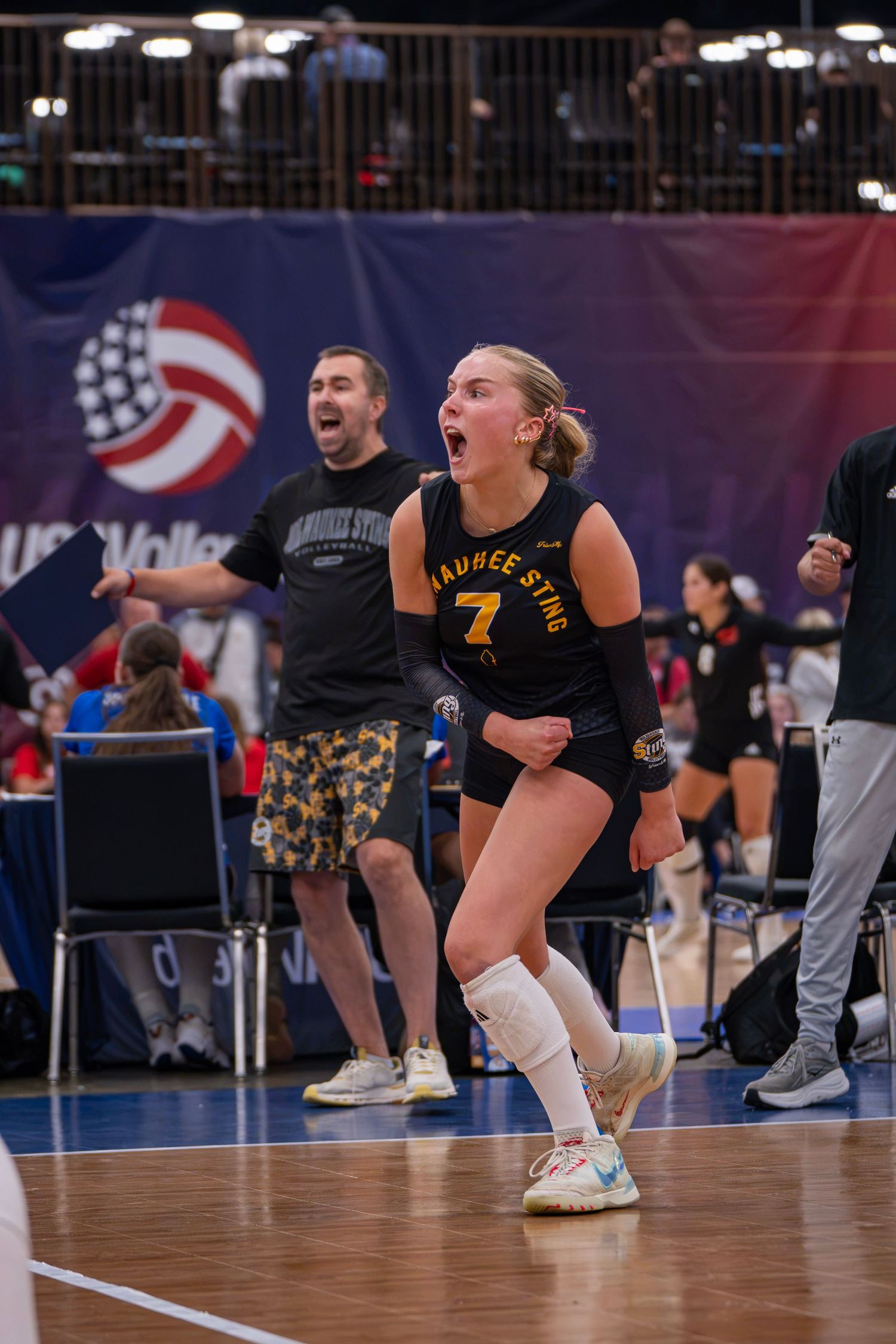 Volleyball player #7 in black Saukee Sting uniform celebrates during a USA Volleyball tournament match.