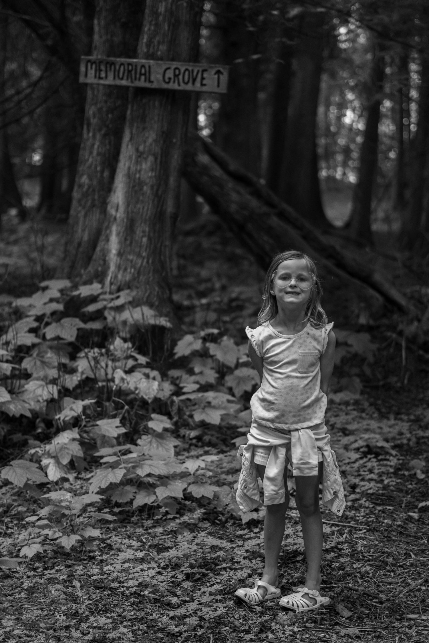 Black and white sequence of a child playing in a forest setting.