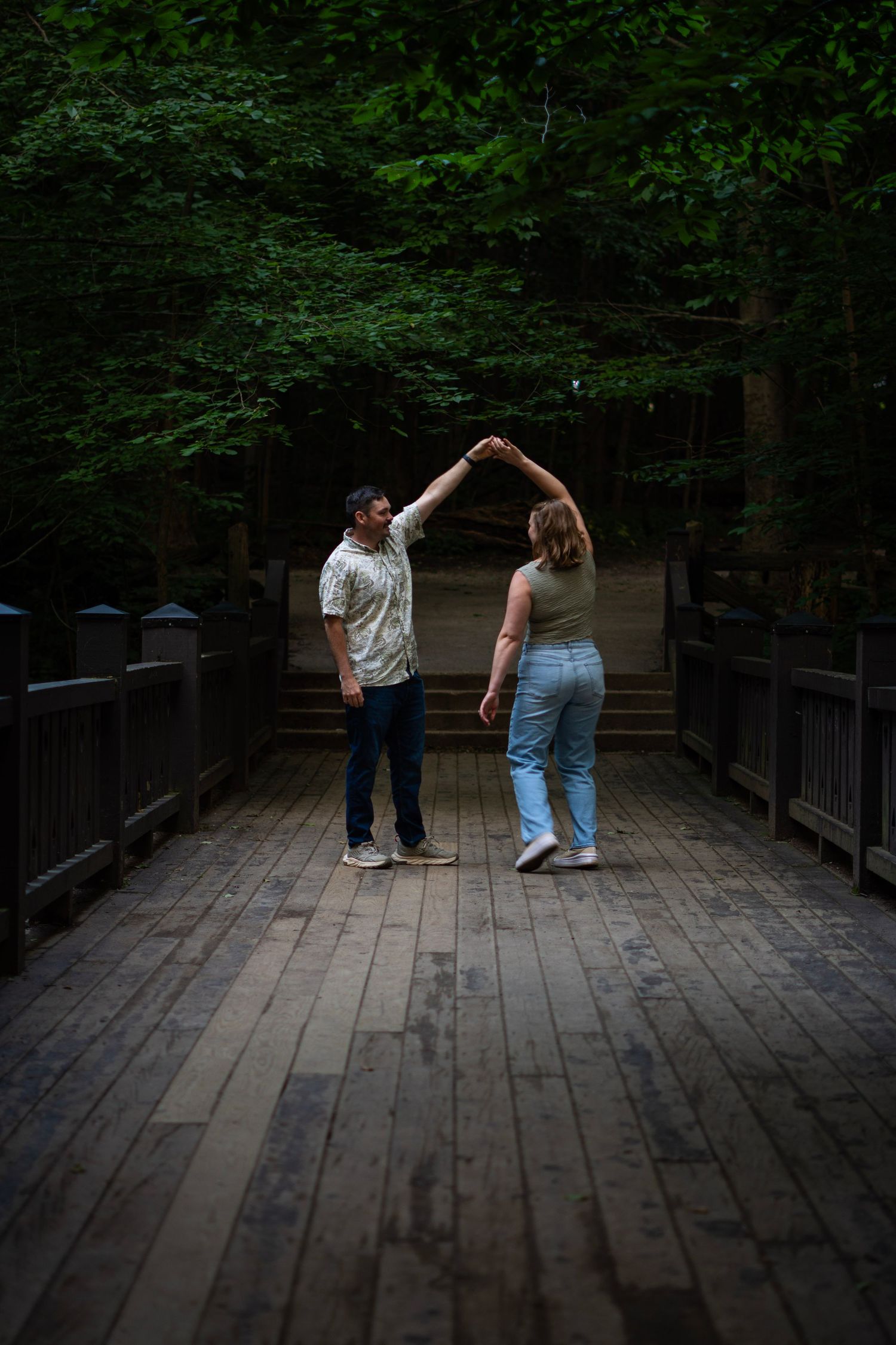 Dancing sequence captured on a wooden boardwalk surrounded by dark forest.