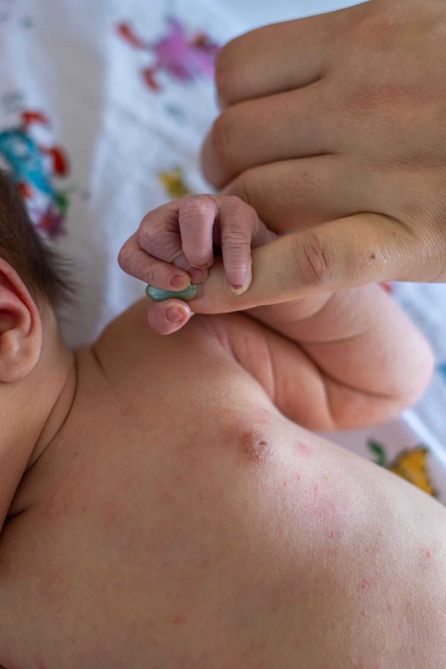 Close-up of gentle hands touching delicate baby skin.