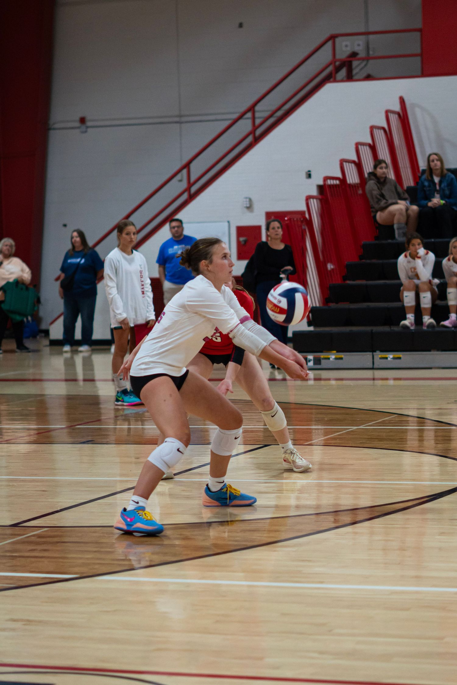 Players diving and sliding across the volleyball court to save a play.