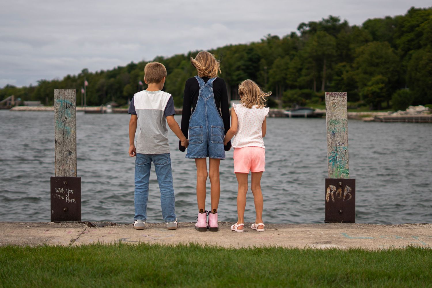 A family stands together looking out over a peaceful lake view.