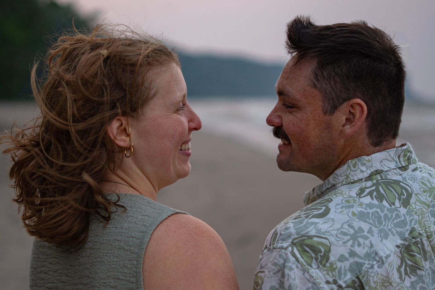 A couple shares intimate moments together on a beach at sunset in a series of romantic photographs.