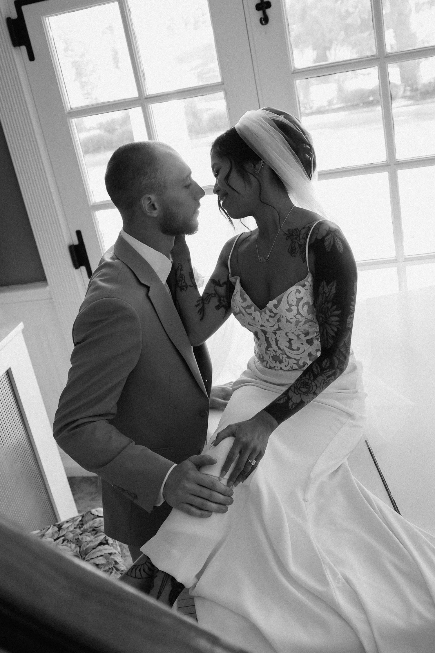 A romantic black and white wedding photo sequence showing tender moments between newlyweds by a window.