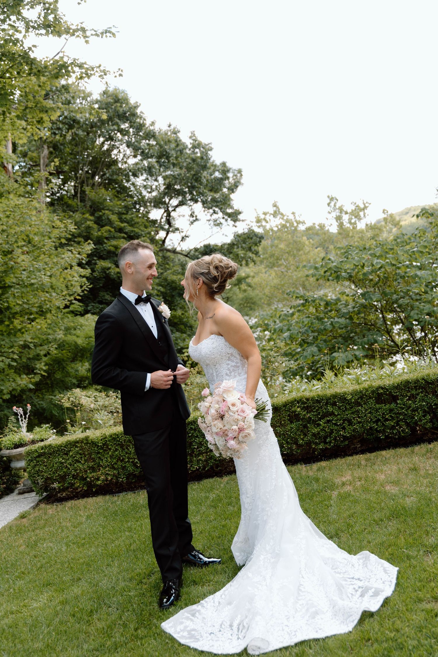 Newlyweds share a romantic first look moment in a lush garden setting.