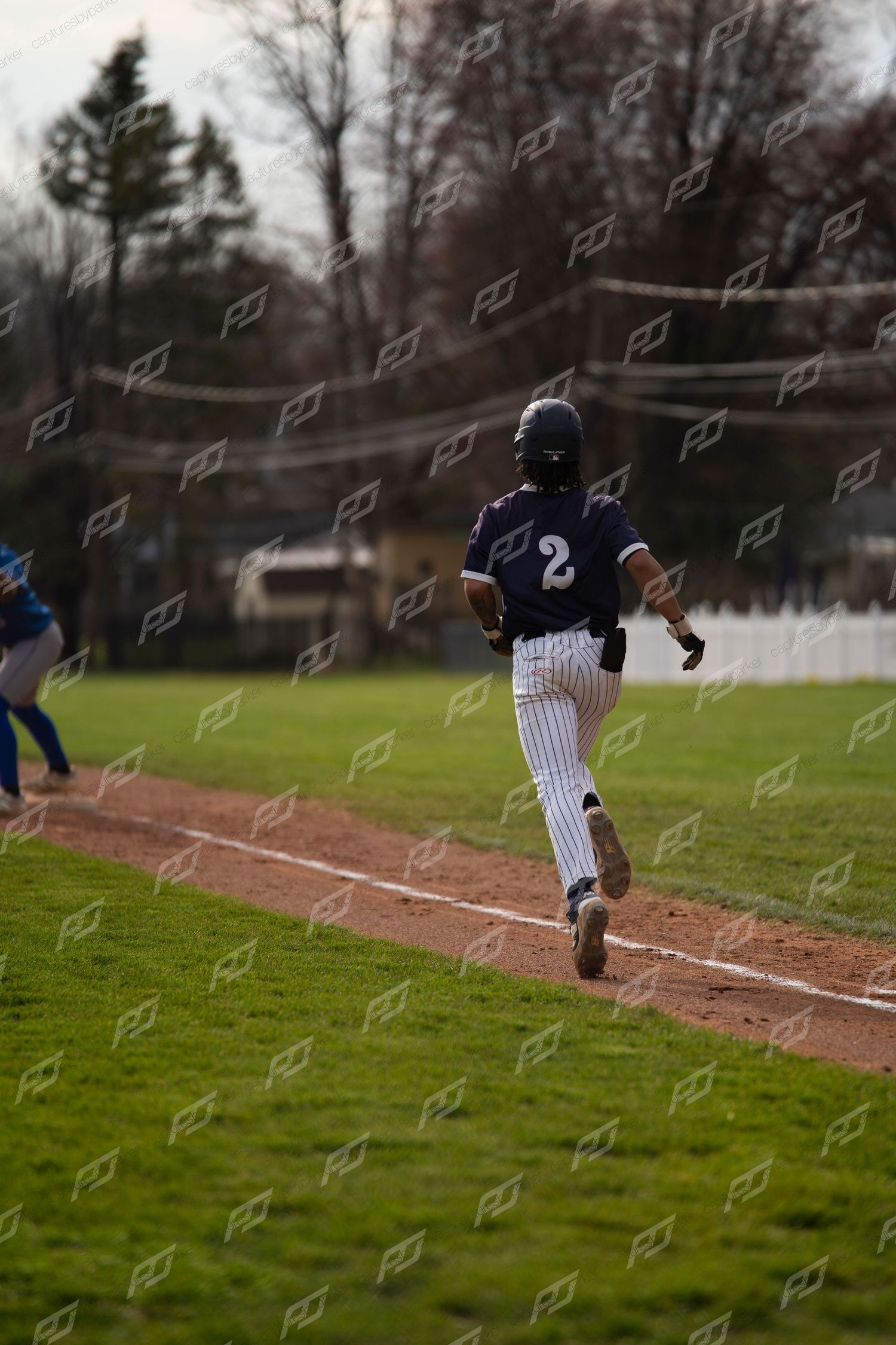 Baseball player #2 in navy pinstripe uniform running the baseline during a game.