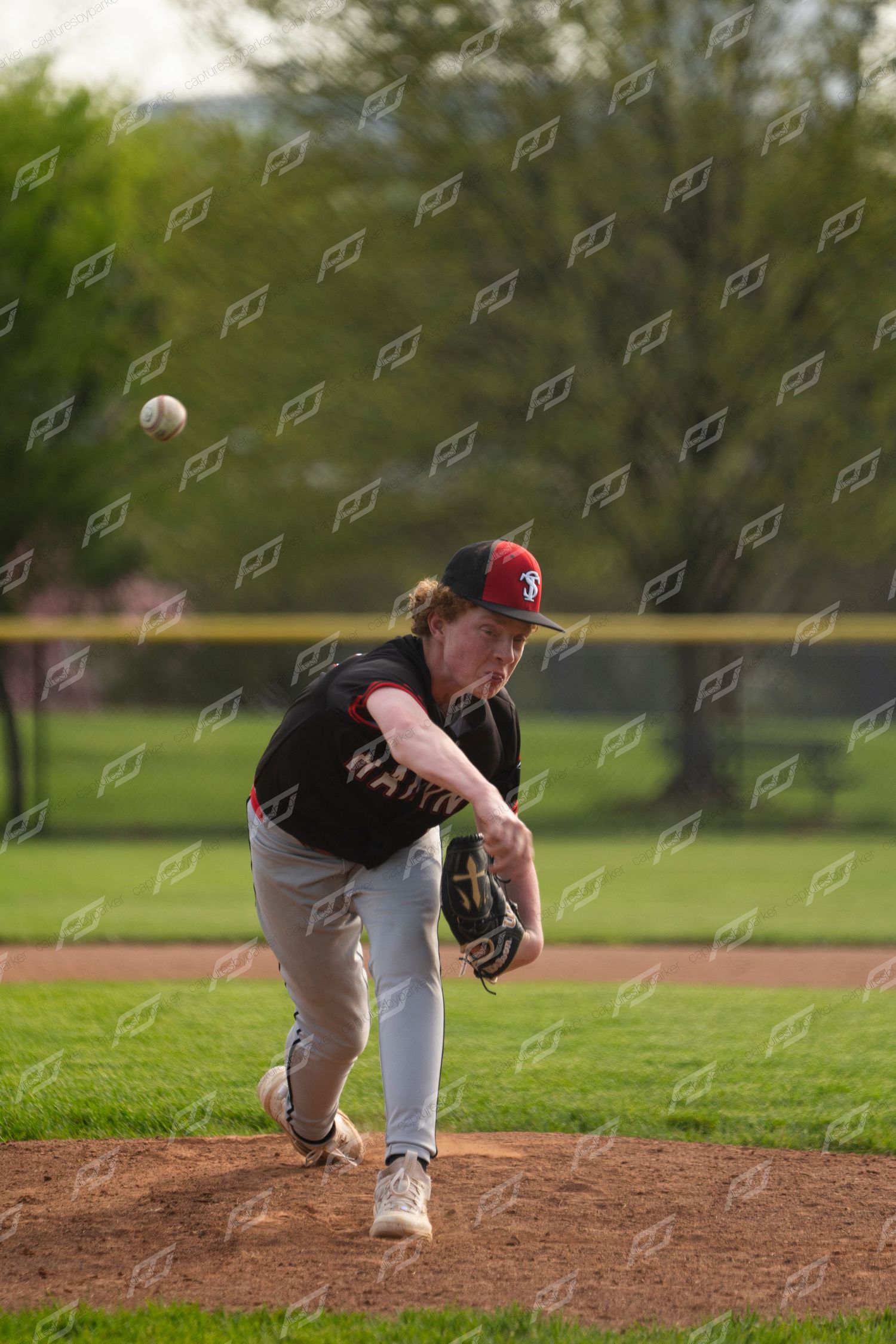 Hanna baseball pitcher releasing the ball from the mound during an outdoor game on a sunny day.