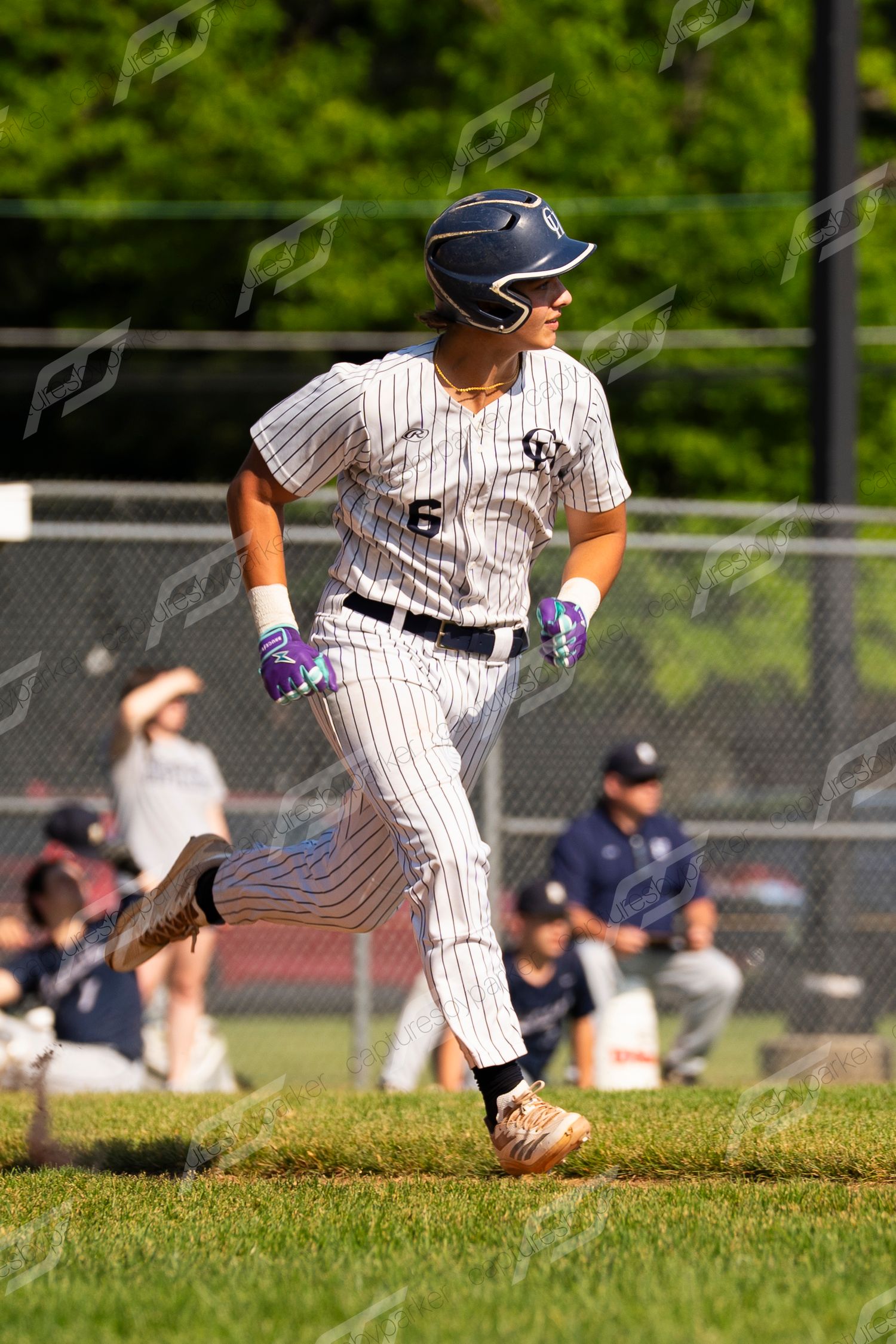 Baseball player #6 in pinstripe uniform sprinting along baseline during a sunny youth league game.