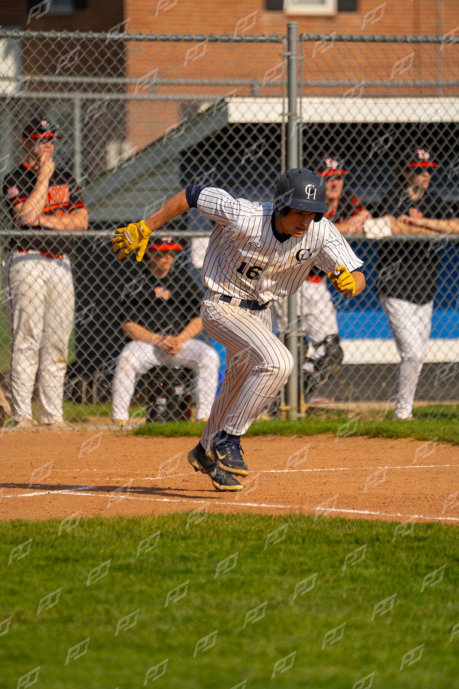 Baseball player in pinstripe uniform sprinting from home plate during a game.