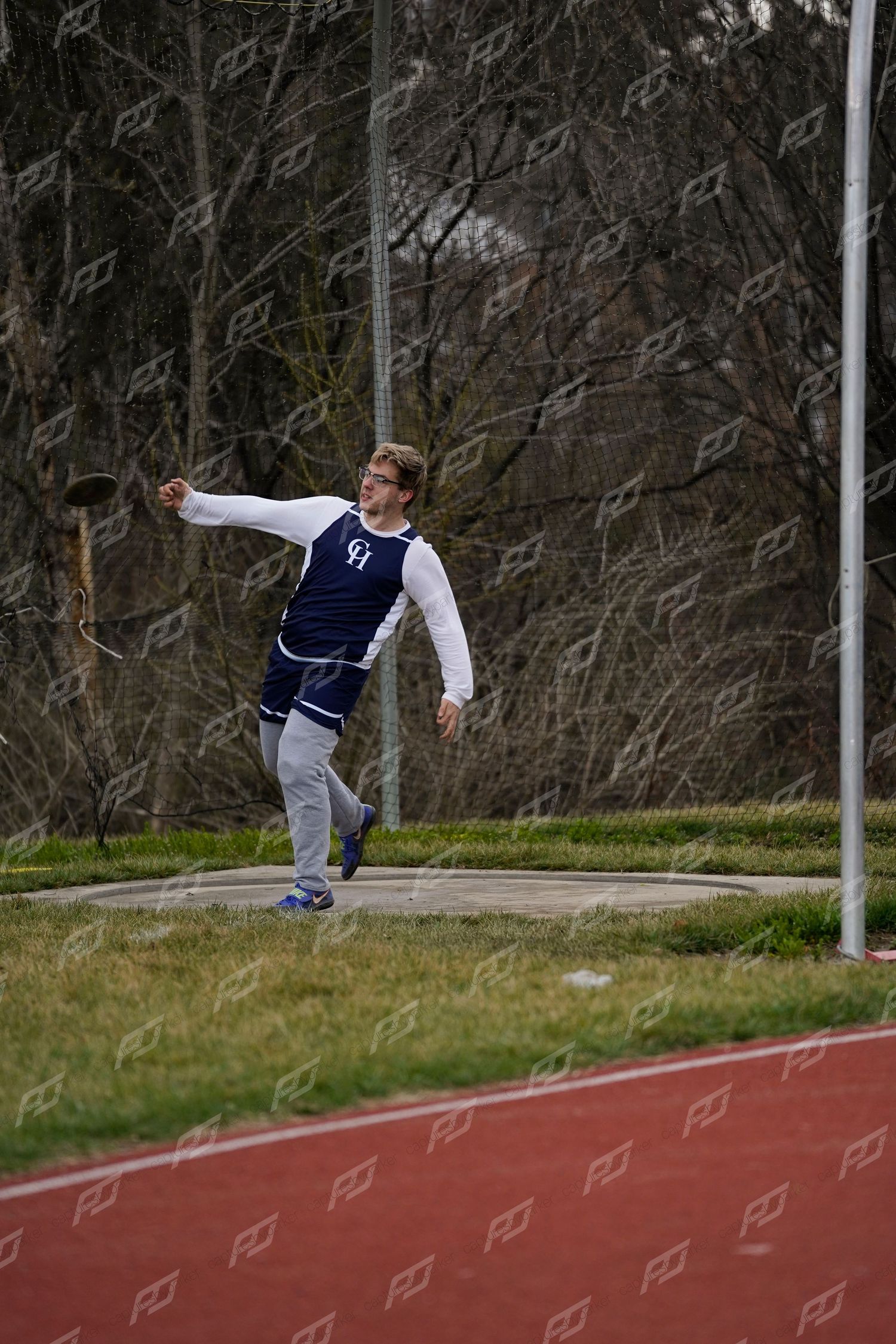 High school male athlete prepares to throw a discus during an outdoor track and field meet.