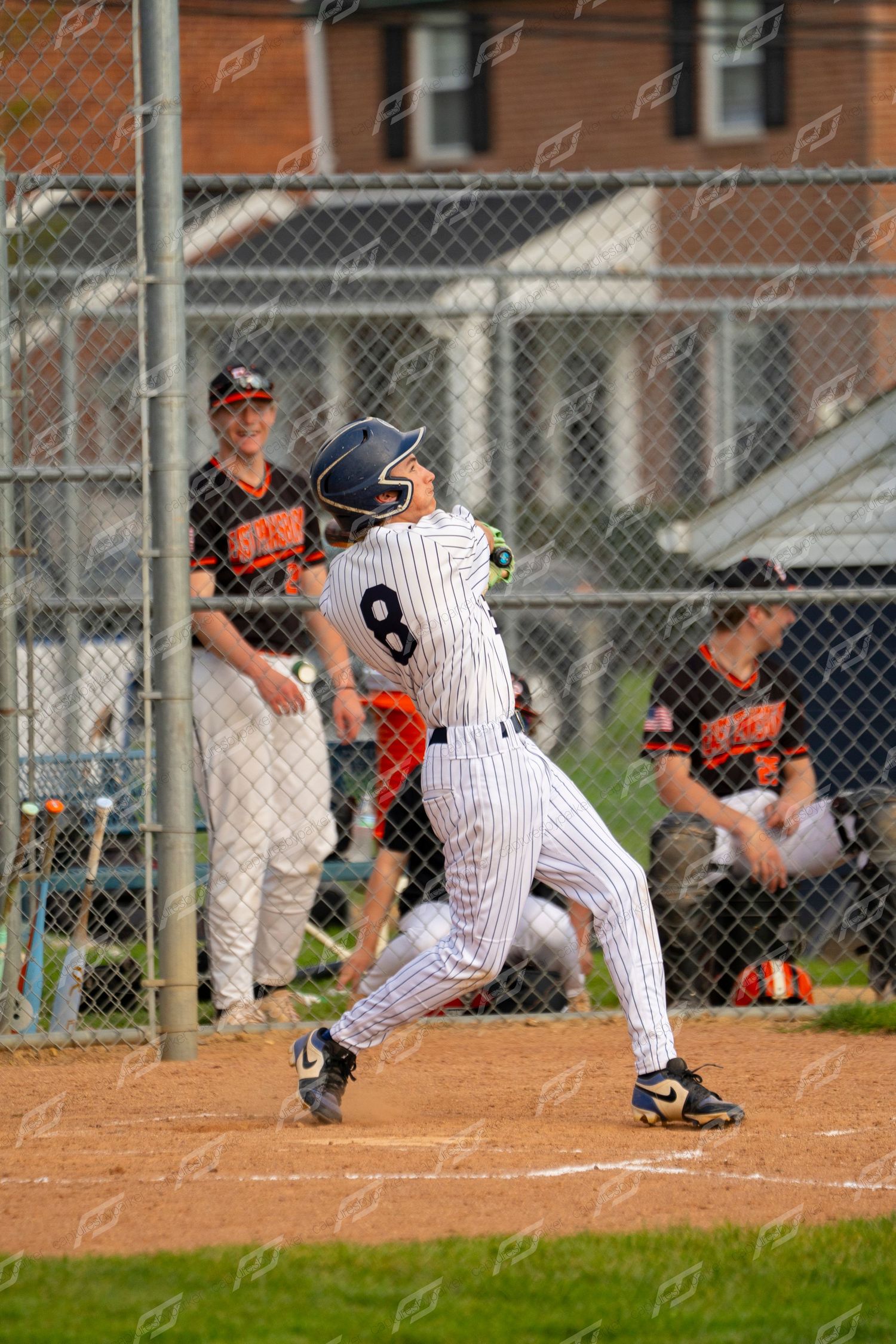 Baseball batter number 8 in pinstripe uniform making contact during a game.