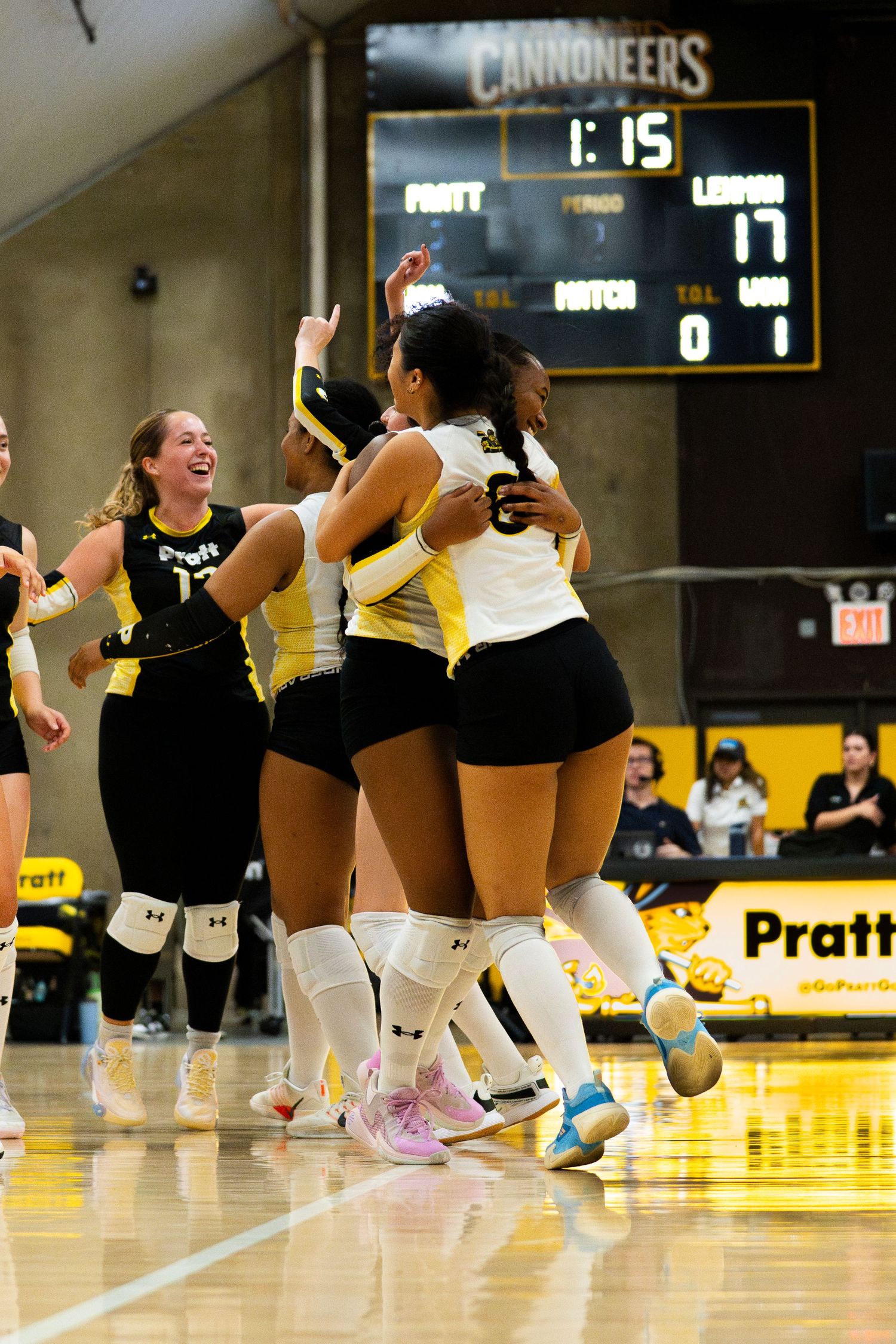 Pratt Cannoneers volleyball players celebrate on court during a match with score 17-0 visible on scoreboard.