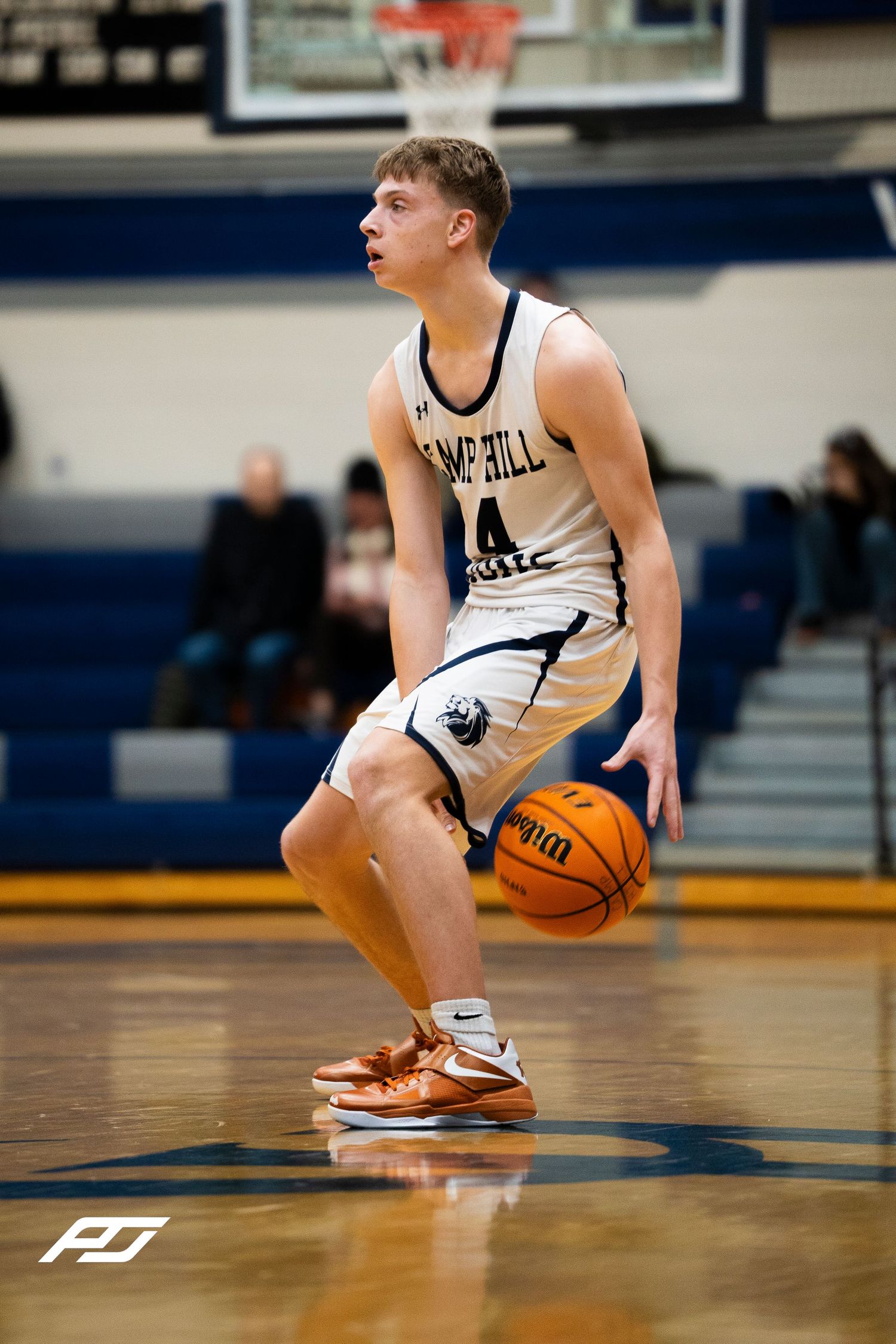 Camp Hill Lions #14 dribbles the basketball during a high school basketball game.