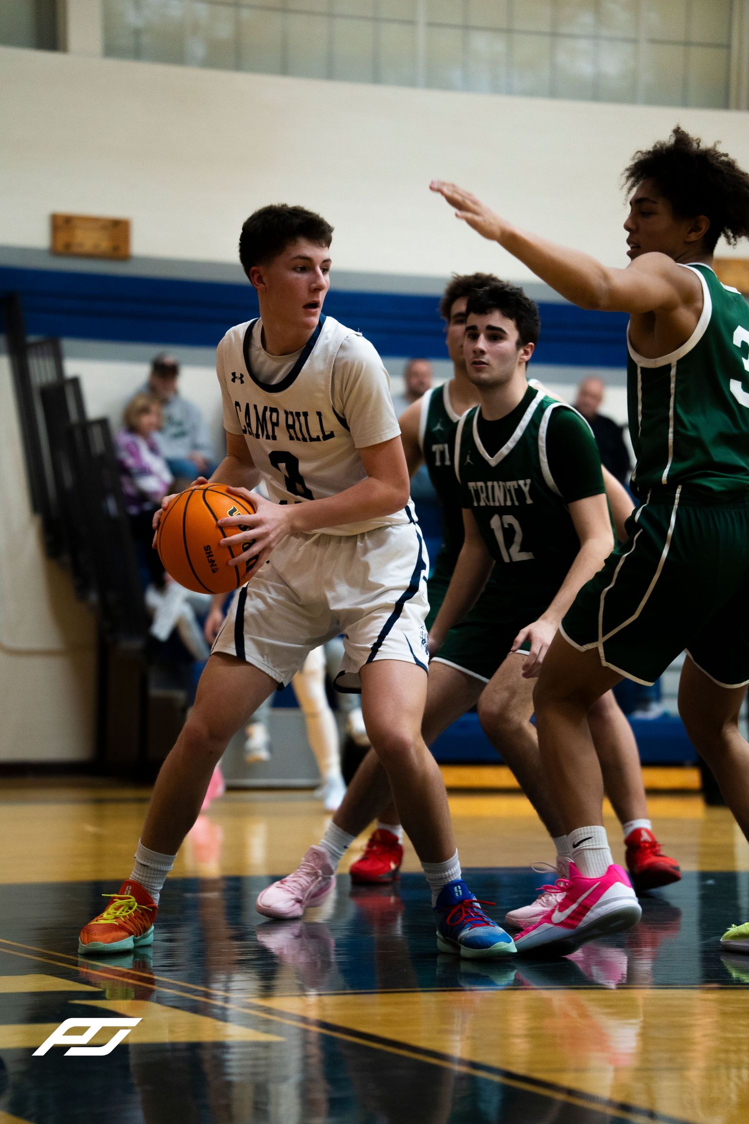 Camp Hill Lions #3 holds the ball while being double-teamed by Trinity players #12 and #3.