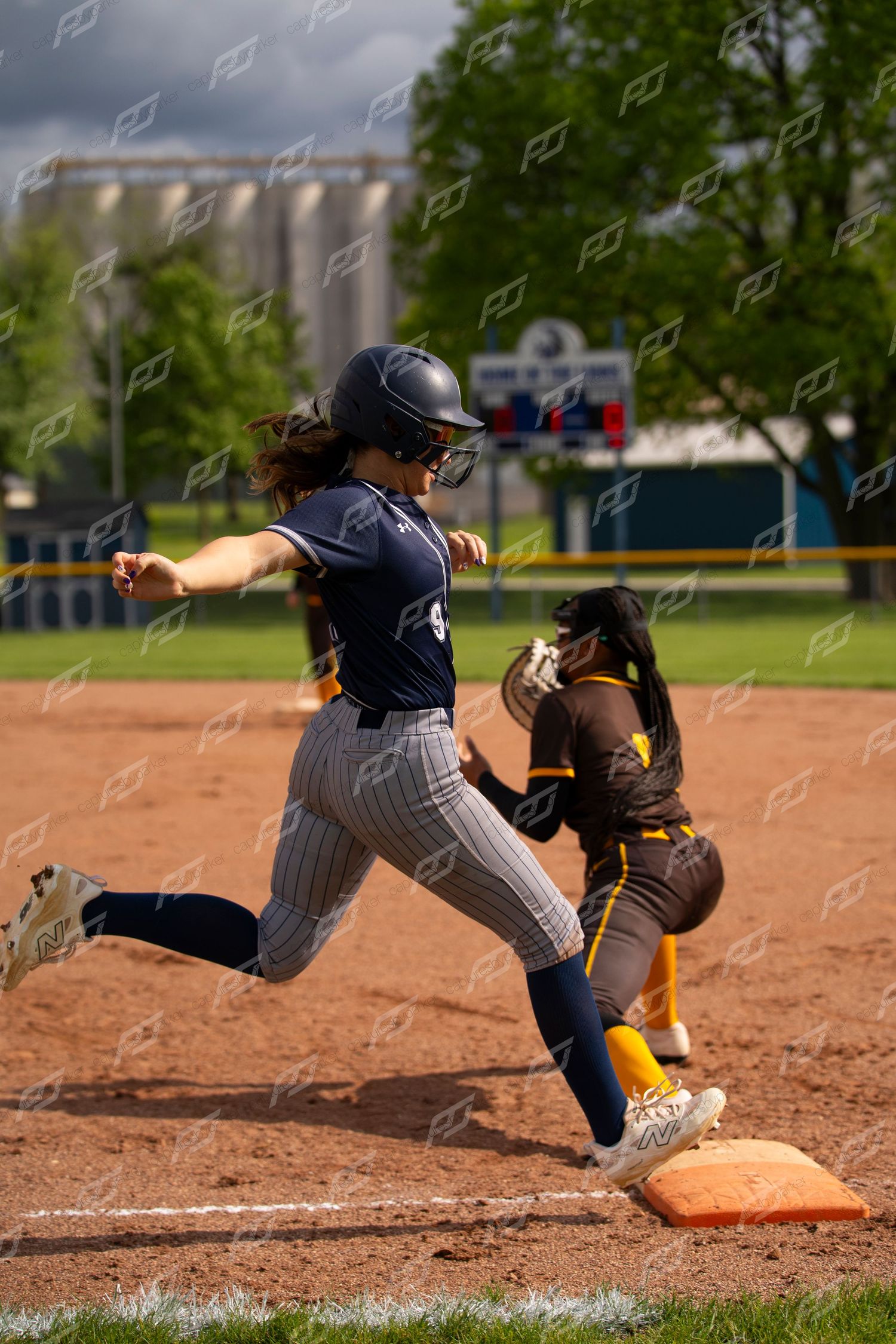 Softball player beats throw to first base during competitive game.