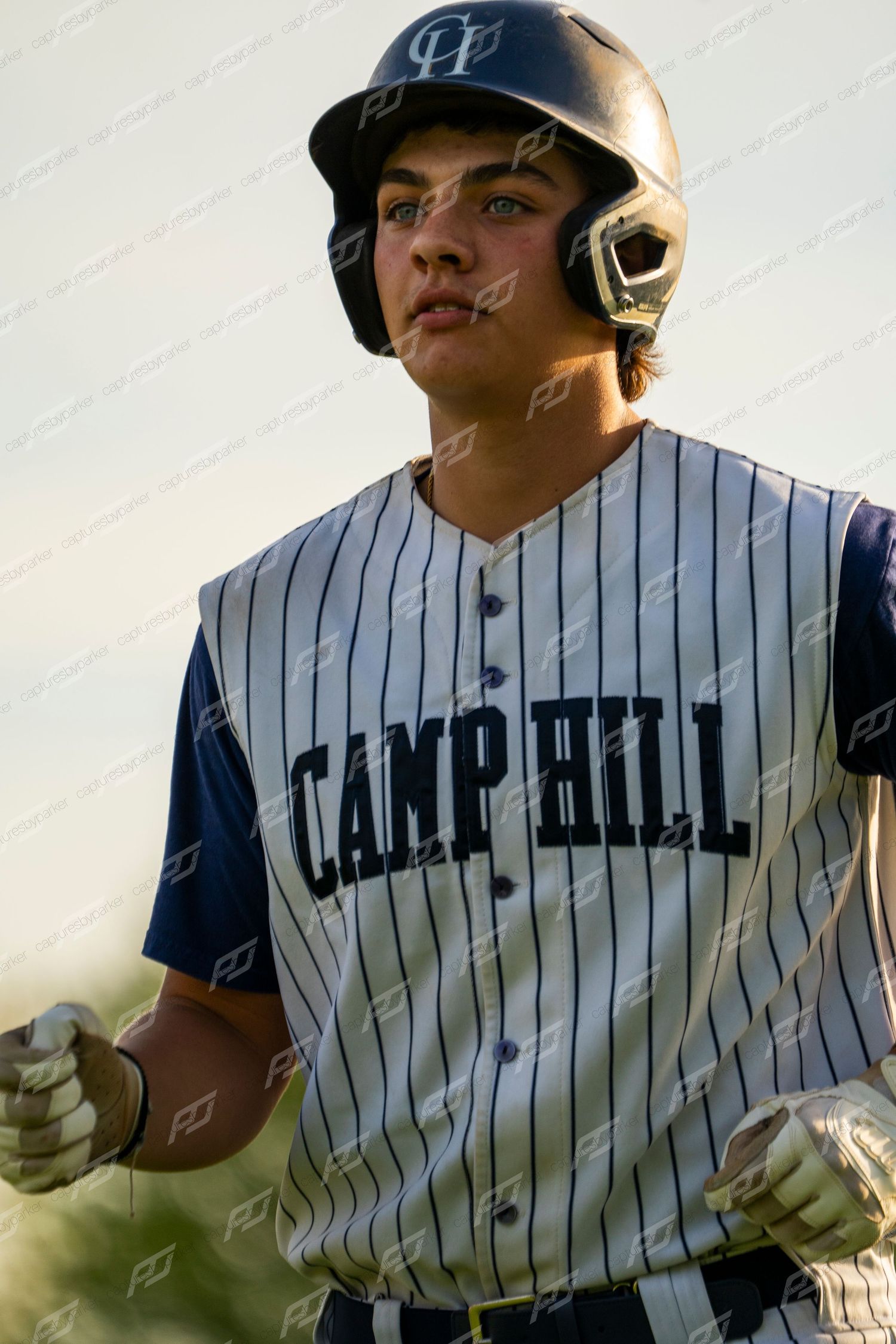 Camp Hill baseball player in batting helmet and pinstripe jersey stands ready at bat.
